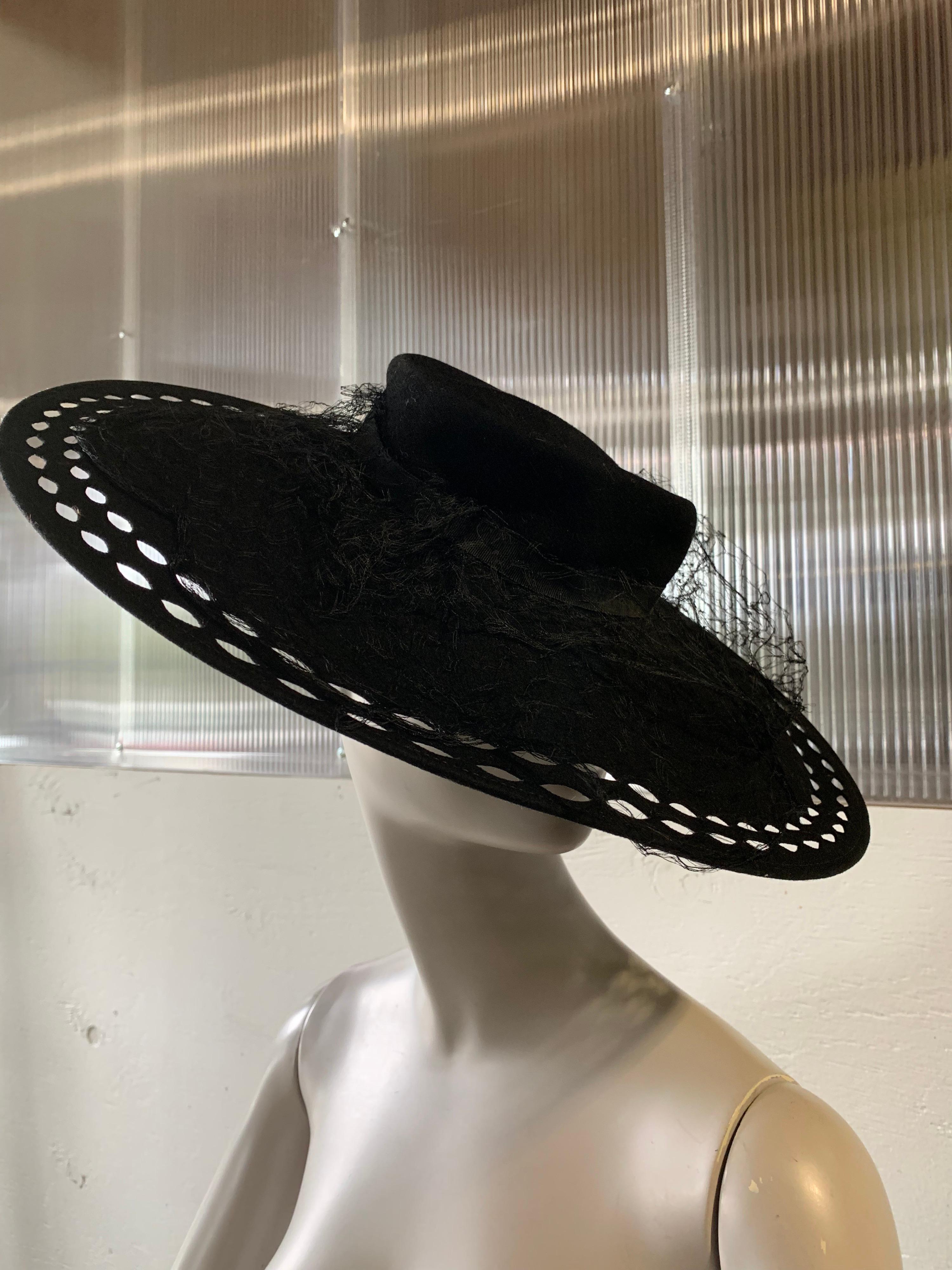 1940s Black Wool Felt Wide Brimmed Hat W/ Marquis-Shaped Cut-Outs And Veiling On Top Of Flat crown. Elastic band to secure. One size.