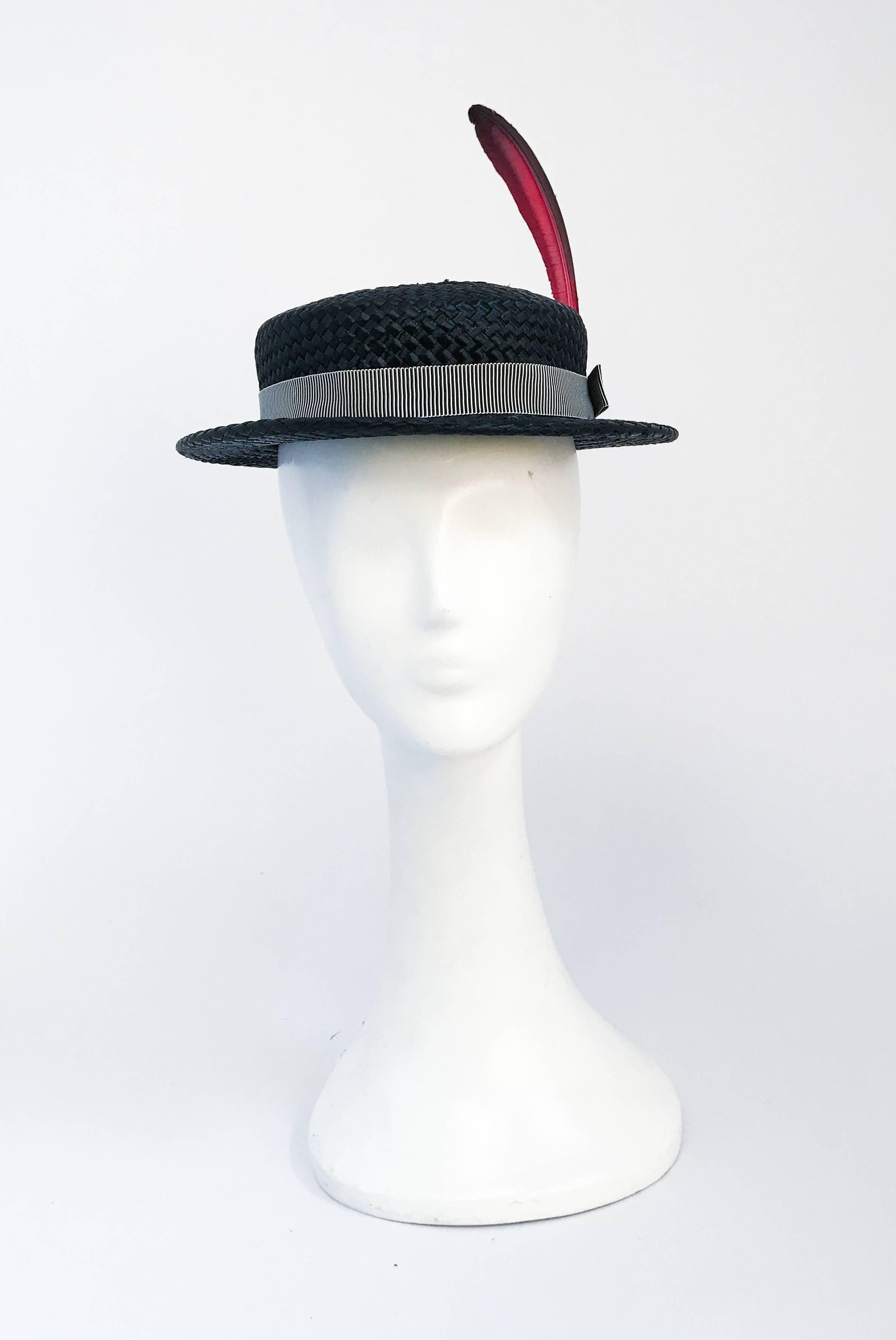 1940s Black Woven Straw Hat with Large Feather Accent. Black woven straw hat with black and white hat band and elongated red/black hand dyed feather accent. Open-sized.
