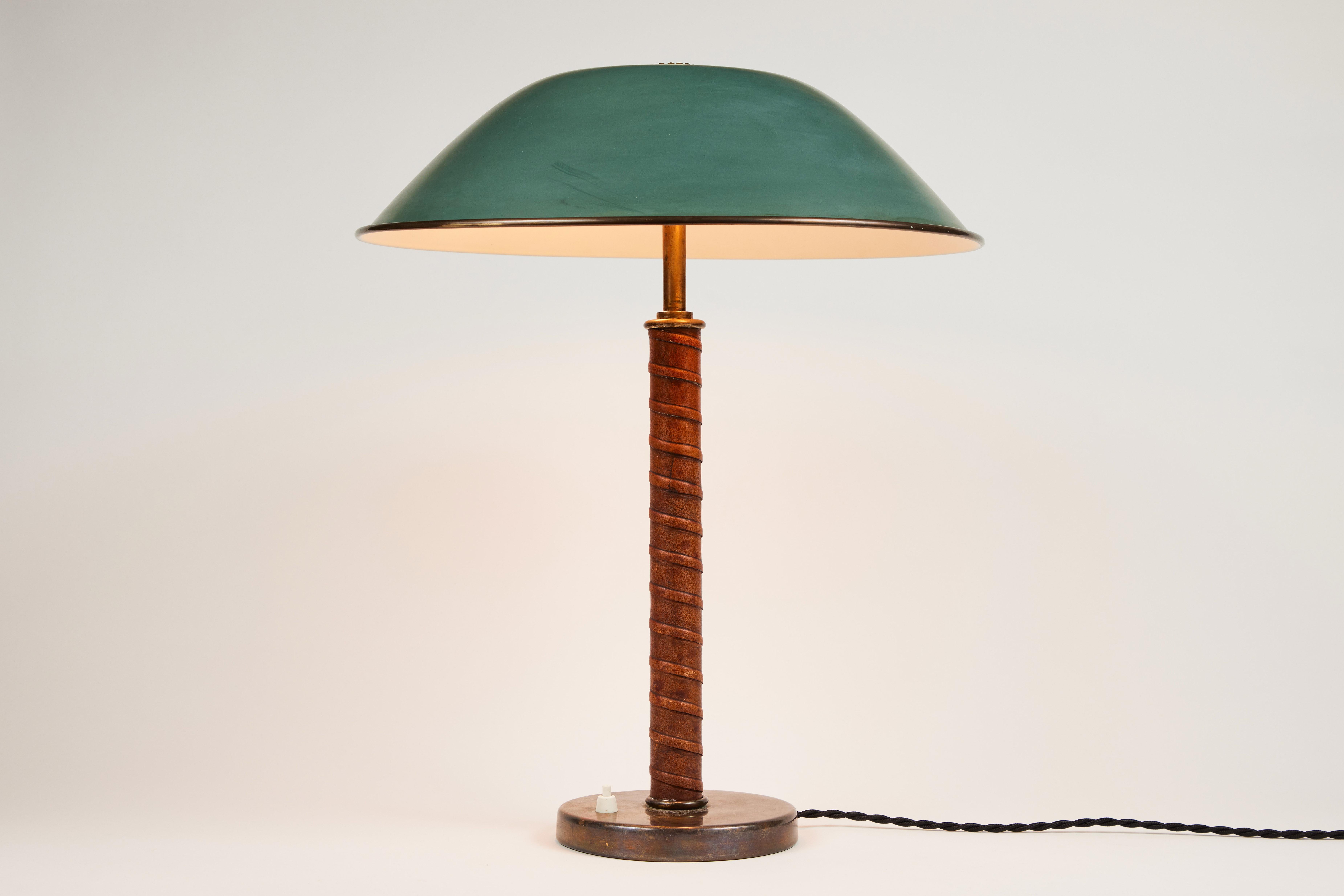 1940s Böhlmarks brass and leather table lamp. Produced by the iconic Swedish lamp maker circa 1940 and executed in green painted metal, brass and beautifully distressed but tight leather wrapping. Reminiscent of the early designs of Paavo Tynell for