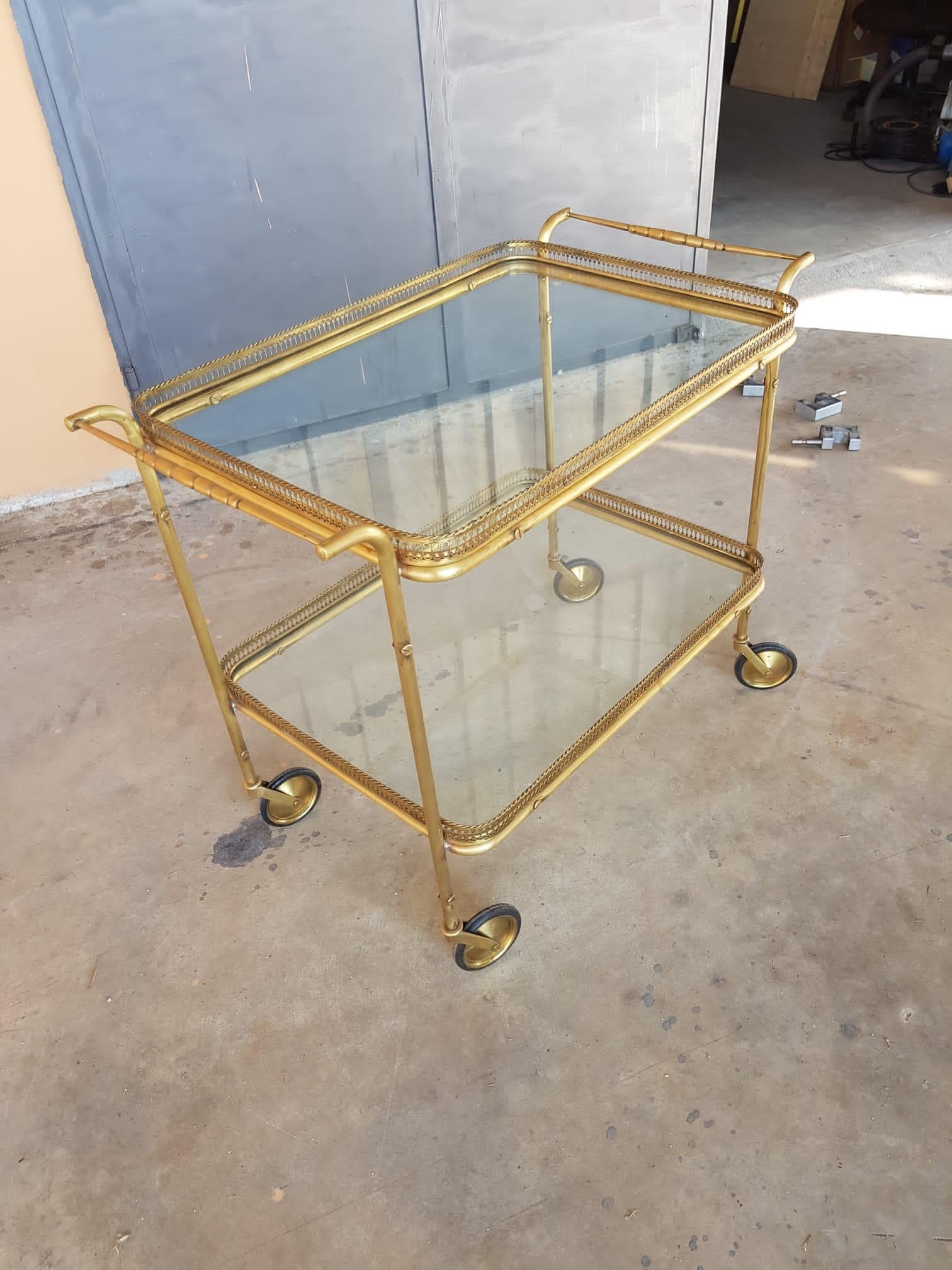 1940s brass and two glass shelves wheeled tray .
Perfect to be used as side table, dry bar or serving table in the kitchen or bathroom.
Restored in conservative way ( brass cleaned ) .
Size: 83 x 49 x h 70 cm 
A video of the item Is available