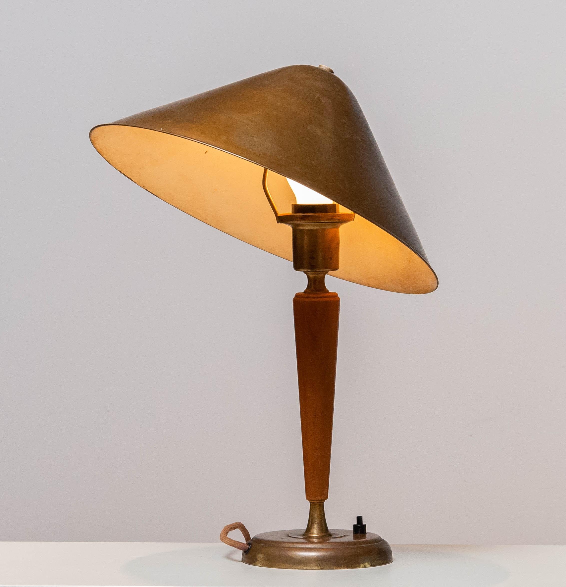 Brass and elm modernist table / desk lamp with beautiful patina true the years by Harald Notini for Böhlmarks in Sweden from the 1940's. 
The shade is adjustable in angle.
Consists one E27 / 28 screw fitting for 110 and 230 volts and in allover good