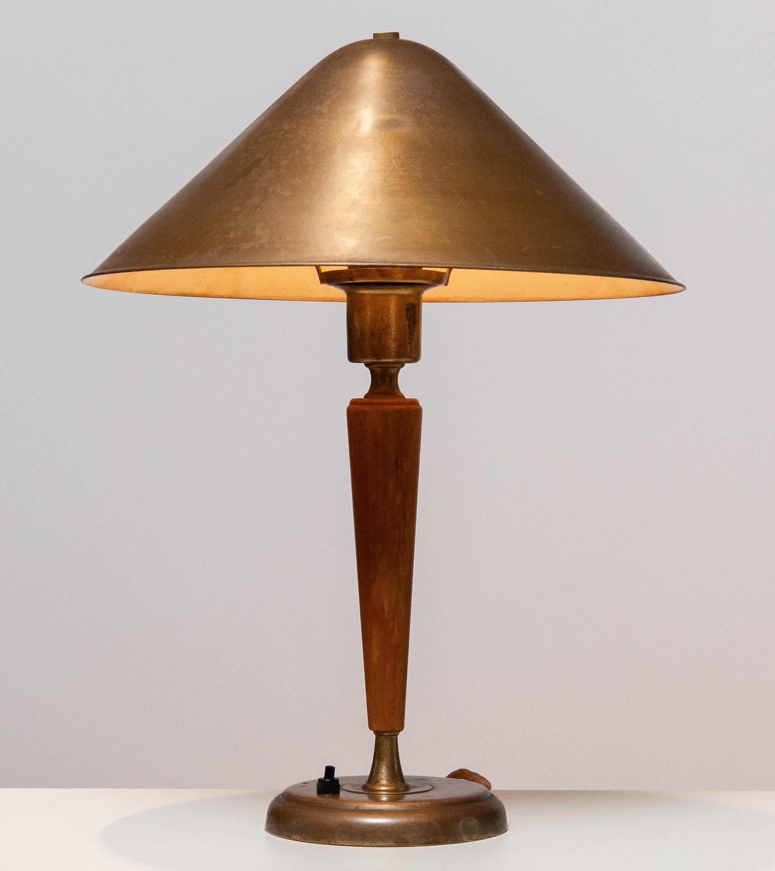 Lampe de table / bureau moderniste en laiton et orme avec une belle patine vraie les années par Harald Norton pour Böhlmarks en Suède des années 1940. 
L'angle de l'abat-jour est réglable.
Condit une douille E27 / 28 pour 110 et 230 volts et en très