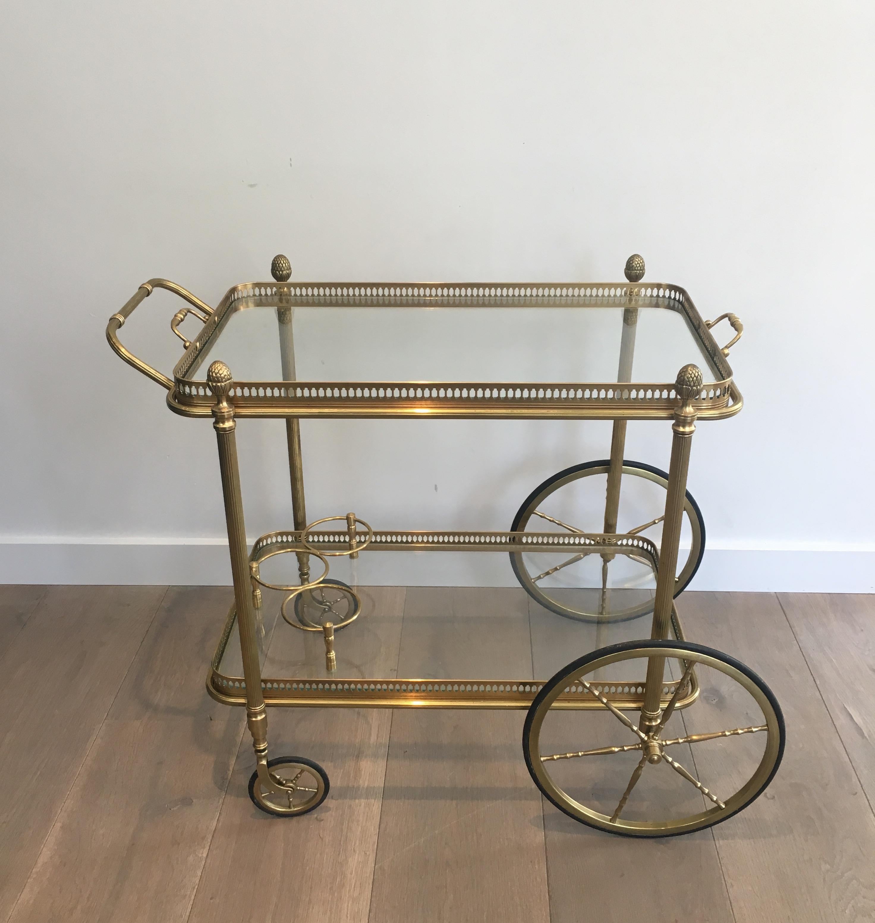 Neoclassical style brass bar cart by Maison Bagués with removable serving tray. The bottom shelf has a bottle holder.

A pair is available. 

This bar cart is currently in France, please allow 4 to 6 weeks for delivery to our warehouse in Long