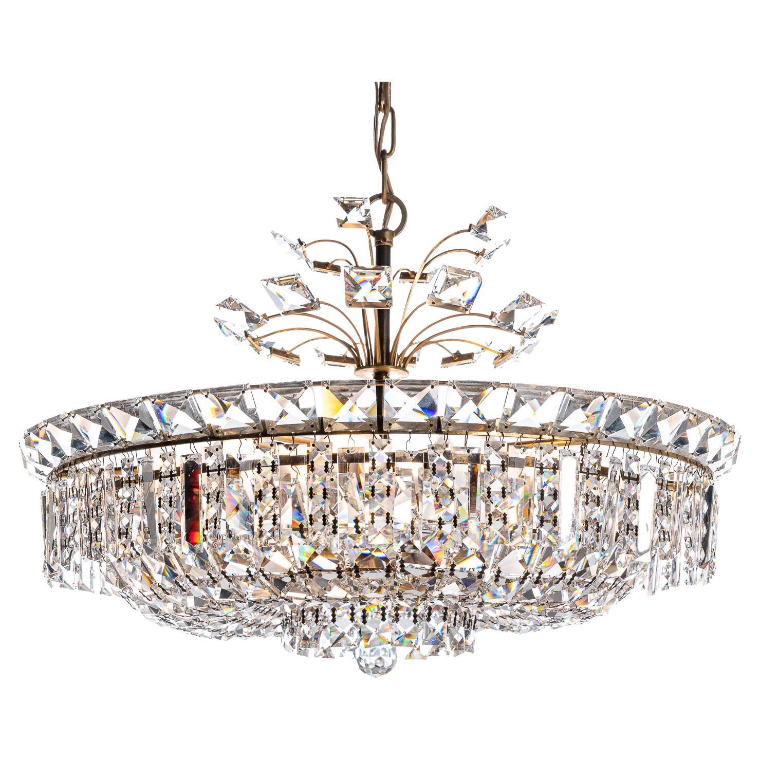This opulent and unique piece is sure to catch the eye. The dazzling crystal glass-work diffuses the light in a beautiful way with a prismatic and shimmering effect.
It also has stunning decorative petal-like design work on the pendant-shaft for