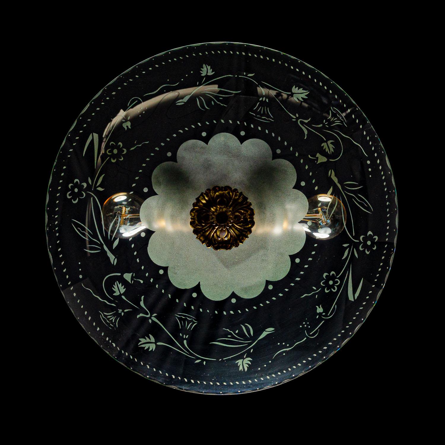 Stylish piece consisting of a brass frame and one glass reflector with a unique floral etching. The etching of the dish makes it seem like the glass has a sloping rim. 
In the center 2 electrical E27 sockets. A unique feature with a soft light.