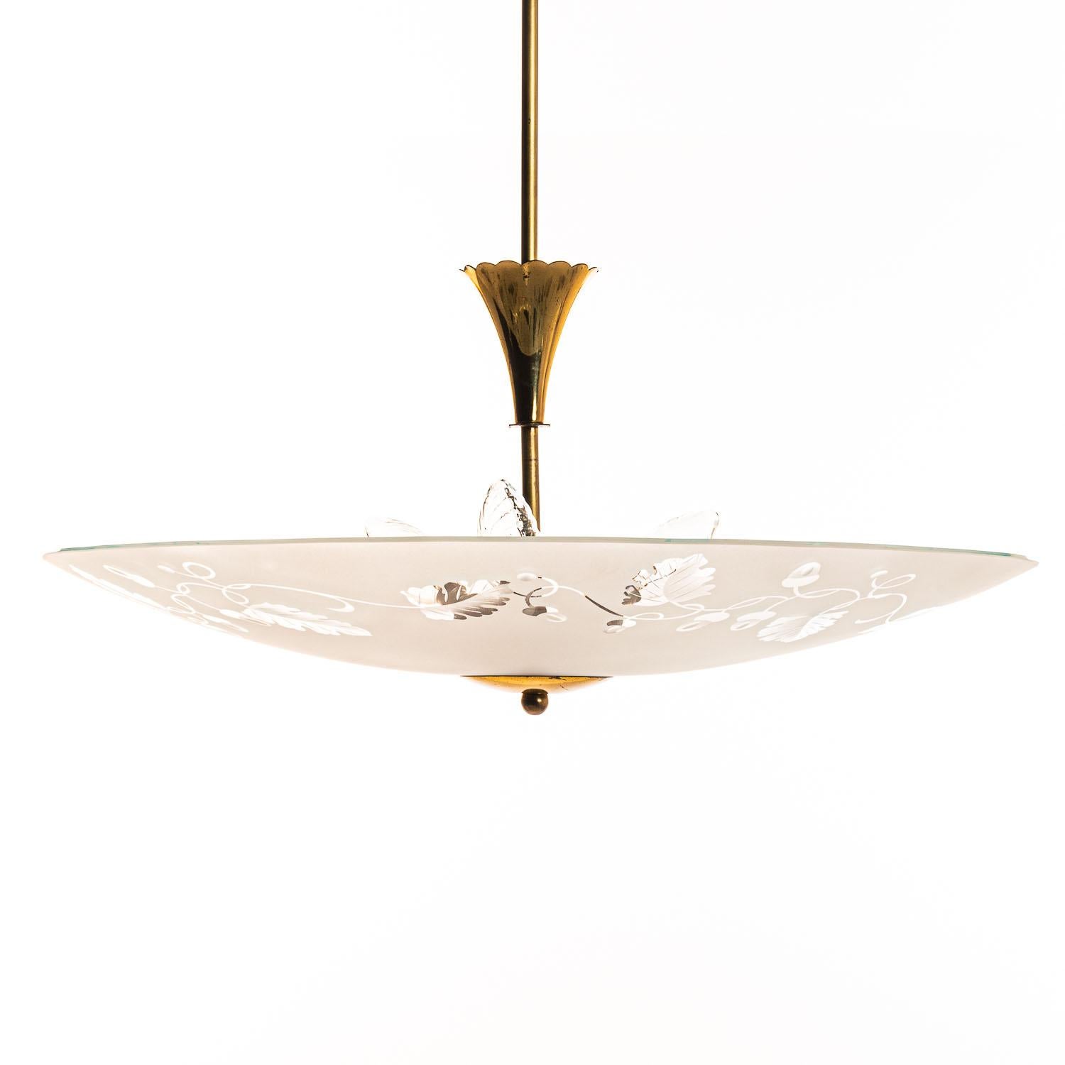 Stylish piece consisting of a brass frame and one glass reflector with a unique floral etching. The etching of the dish makes it seem like the glass has a sloping rim. 
In the center 3 electrical E27 sockets. A unique feature with a soft light.