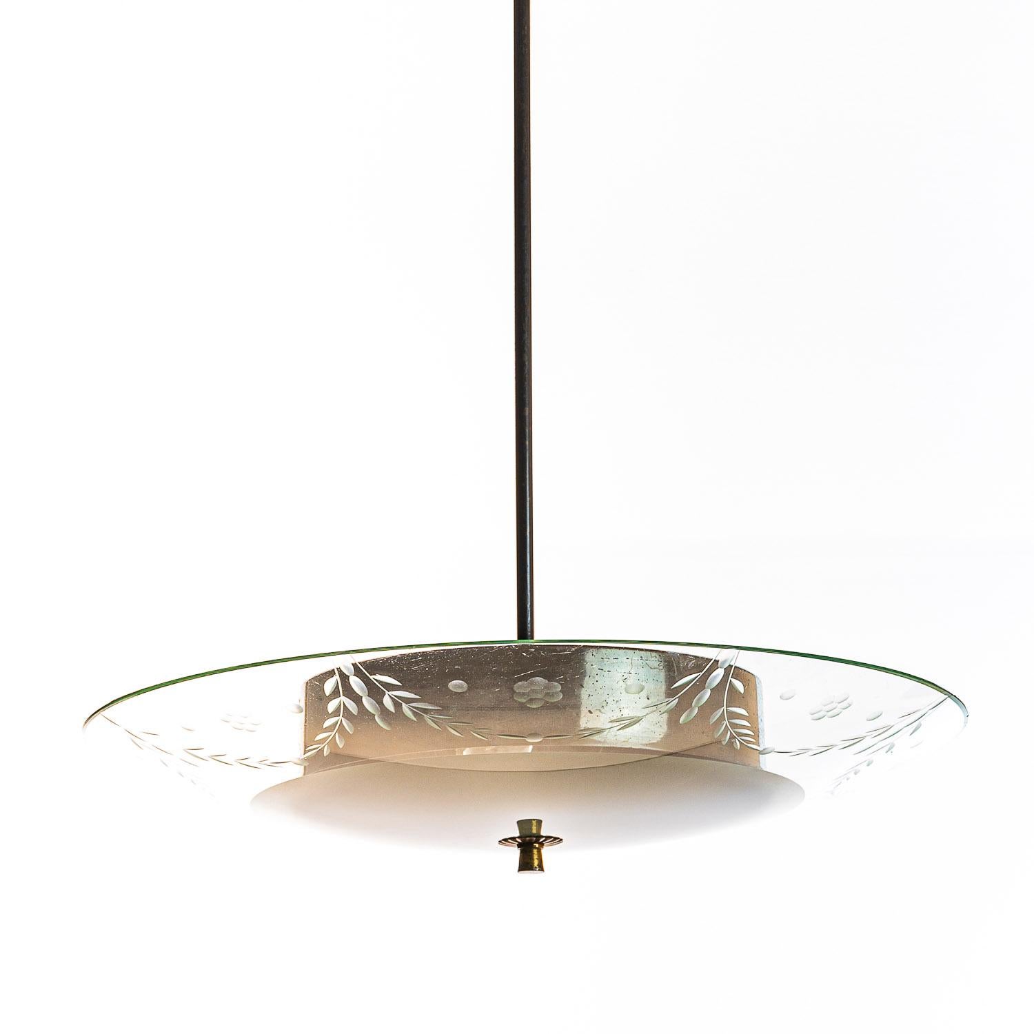 This elegant piece consisting of a brass frame and a unique frosted and satin glass reflector. 
The round curved glass reflector partially etched with floral motifs mounts below a round metal piece to conceal the bulbs. In the center 2 electrical