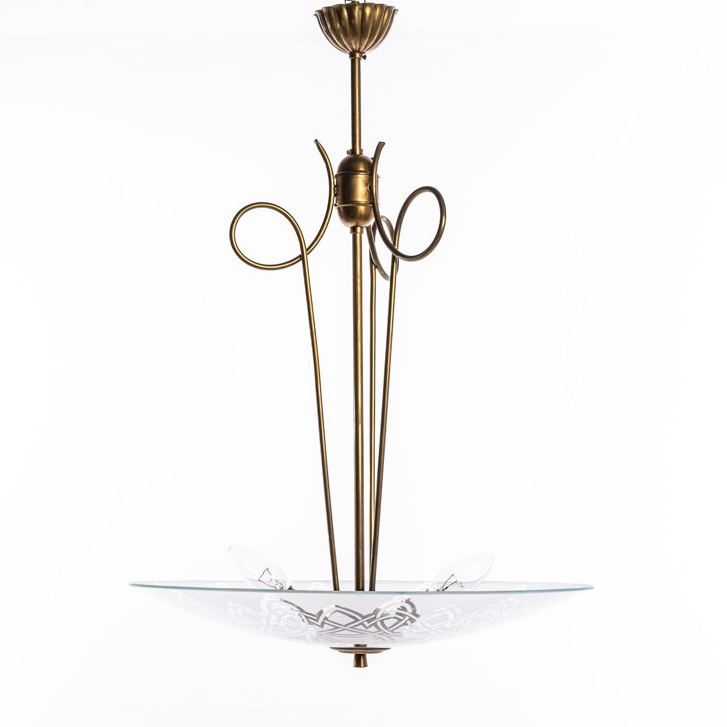 Cette pièce élégante se compose d'un cadre en laiton et d'un réflecteur unique en verre dépoli et satiné. 
Ce réflecteur rond et incurvé en verre, avec son superbe motif, est monté sous un centre en laiton contenant deux douilles électriques E14 et
