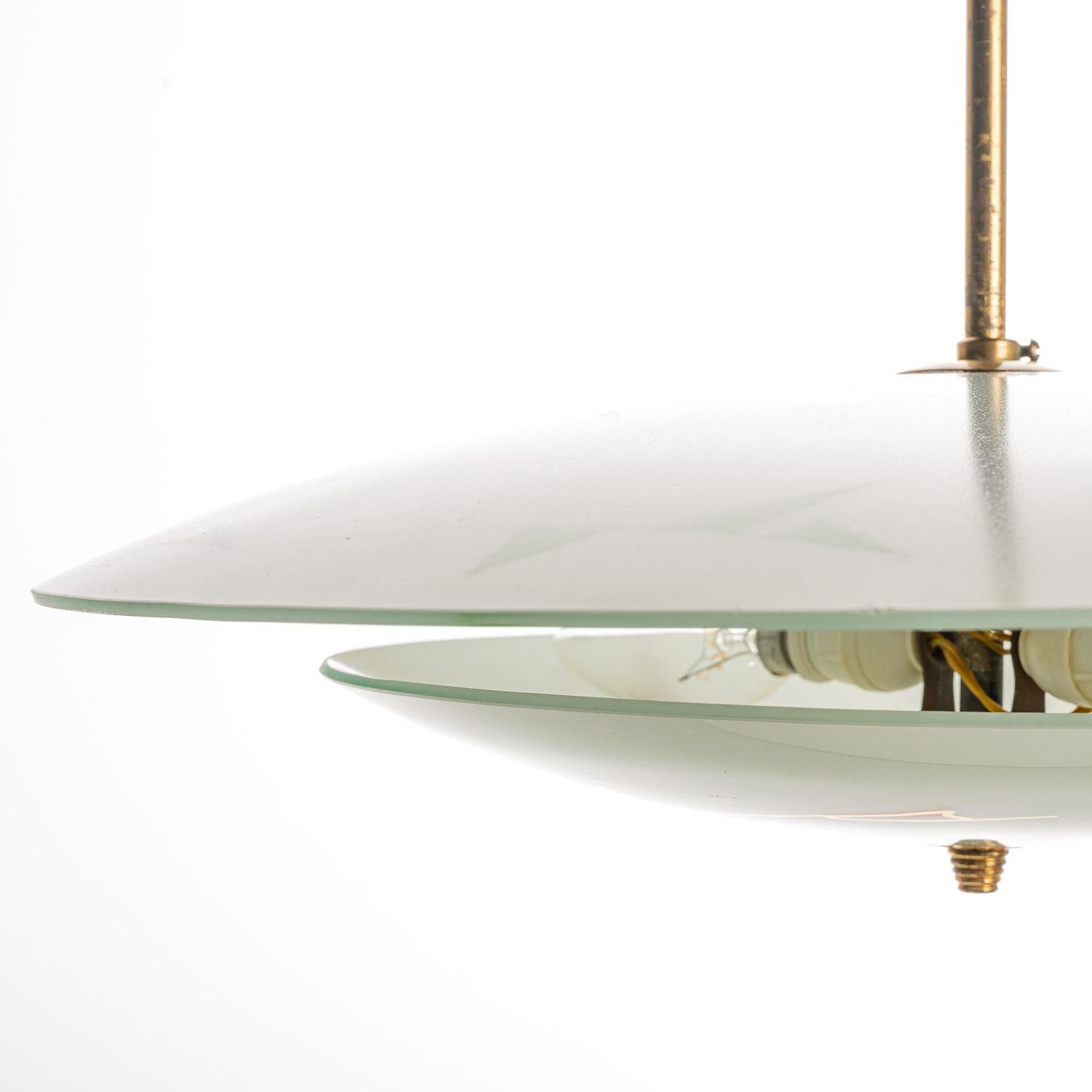 Elegant light consisting of a brass frame and 2 unique frosted and satin glass reflector/saucers. 
The lower round curved glass reflector with a colorful motif mounts below a round satin glass reflector. In the center 2 electrical E14 sockets.