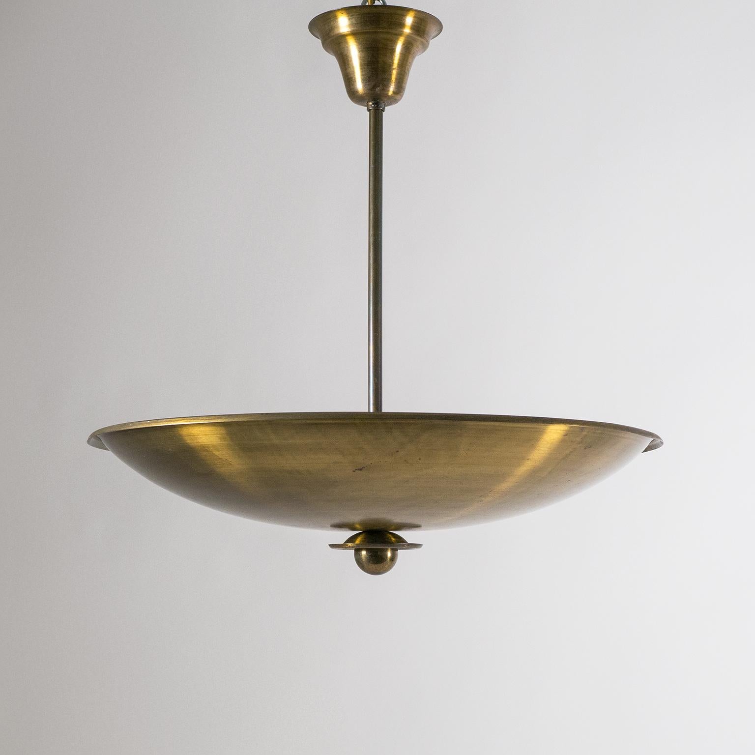 Excellent uplight chandelier from the 1940s made of very solid brass. A rare combination of Art Deco craftmanship and details with midcentury minimalism. Nice original condition with beautiful patina on the brass and some wear to the original