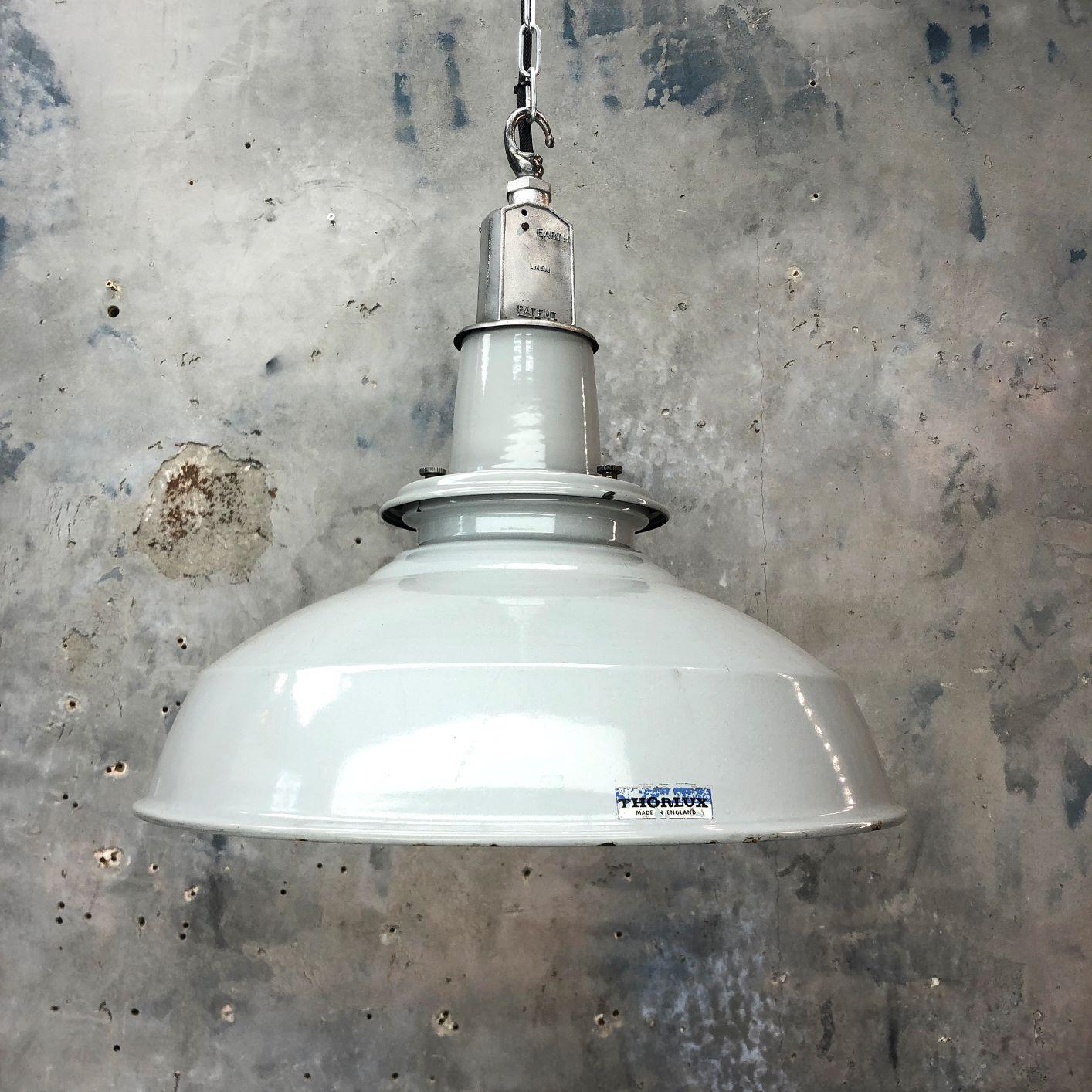 A midcentury Classic industrial grey enamel factory ceiling light made in England by Thorlux.

Thorlux are a designer, manufacturer and supplier of professional lighting systems since 1936. This factory pendant has been restored by hand in UK by