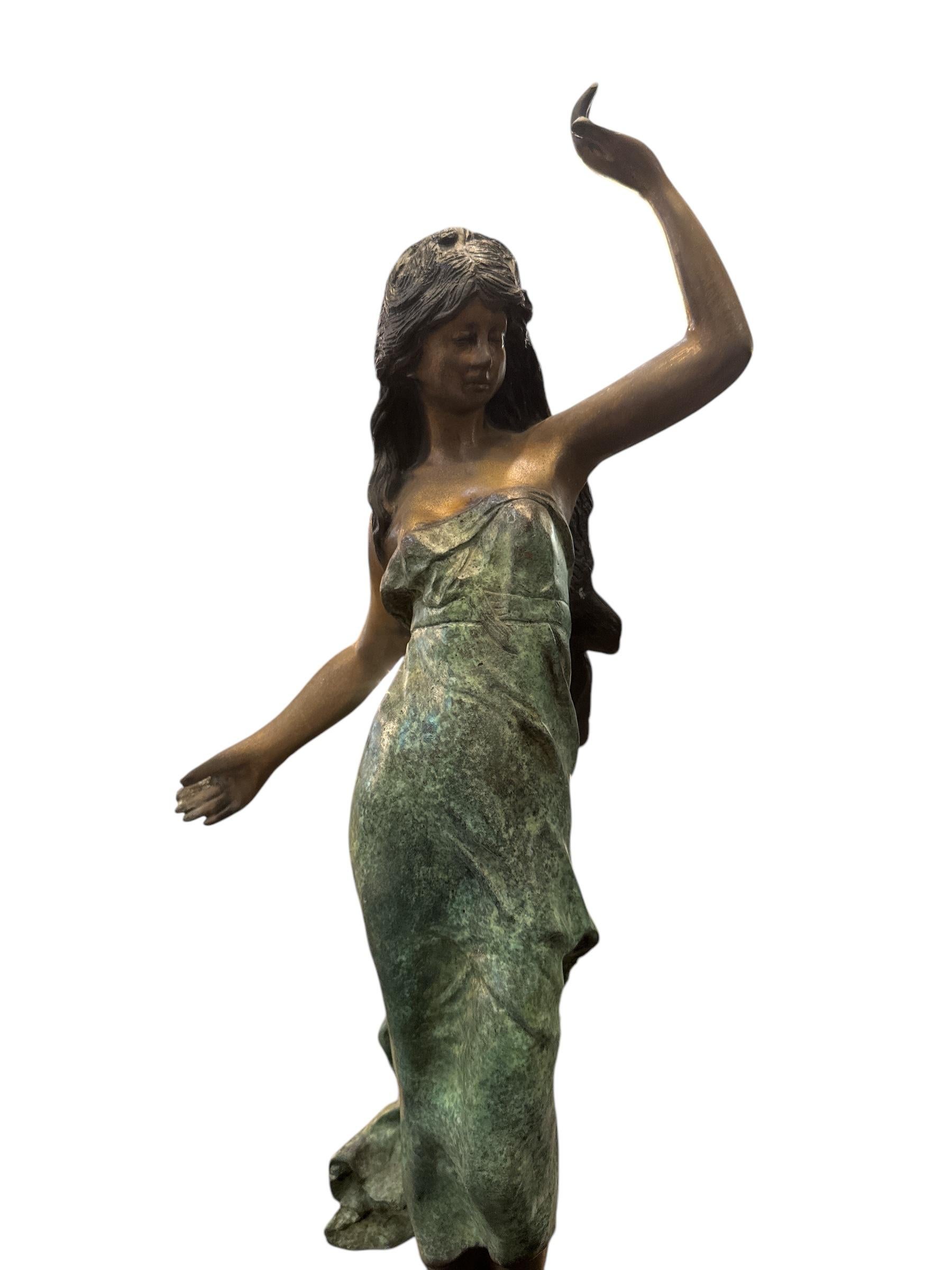 Questa elegante statua di bronzo degli anni '40 cattura la grazia e la raffinatezza dell'arte di metà secolo. Realizzata in bronzo pregiato, la statua presenta una splendida signora in un fluente abito verde, che emana una bellezza e un fascino