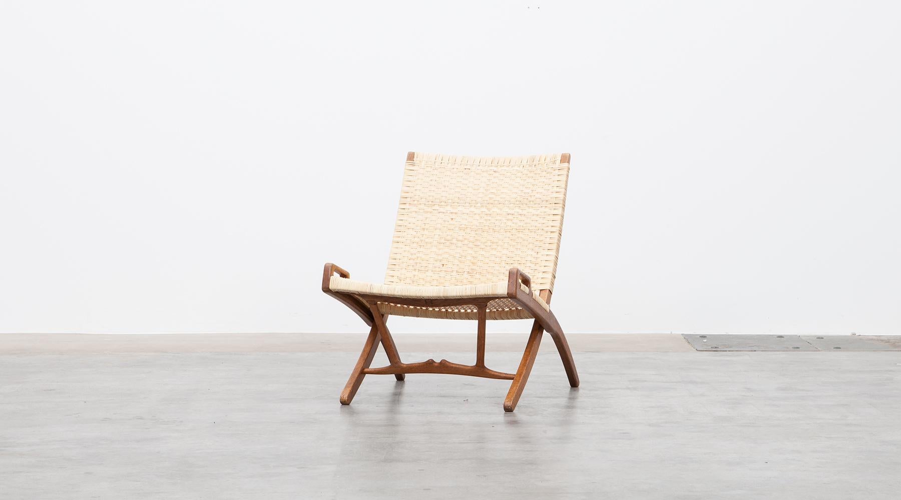 Folding chair in brown oak, white cane by Hans Wegner, Denmark, 1949.

The folding chair comes with a hook that can be attached to a wall. Designed by Hans Wegner. This beautiful and also practical piece comes in good condition, in white cane and