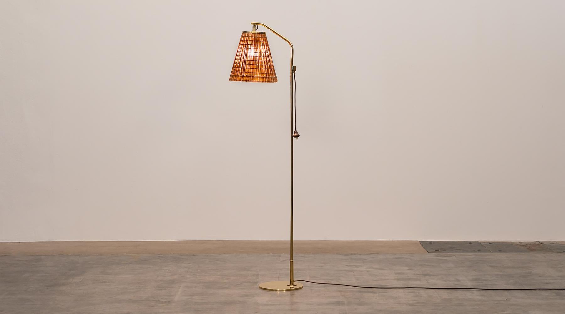 Wicker lampshade and brass stem floor lamp by Paavo Tynell, Finland, 1940s.

Very elegant floor lamp designed by famous Finnish Paavo Tynell giving a warm charming light. The 