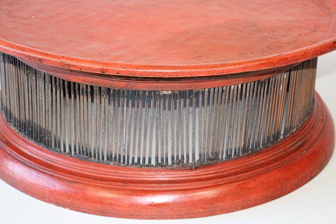 Early 20th century large Burmese lacquered bamboo tray handcrafted red Thai lacquered rattan footed stand.
This Thai features a drum shape circular tray top sitting above a body rhythmically accented with spindle motifs, the ensemble resting on a
