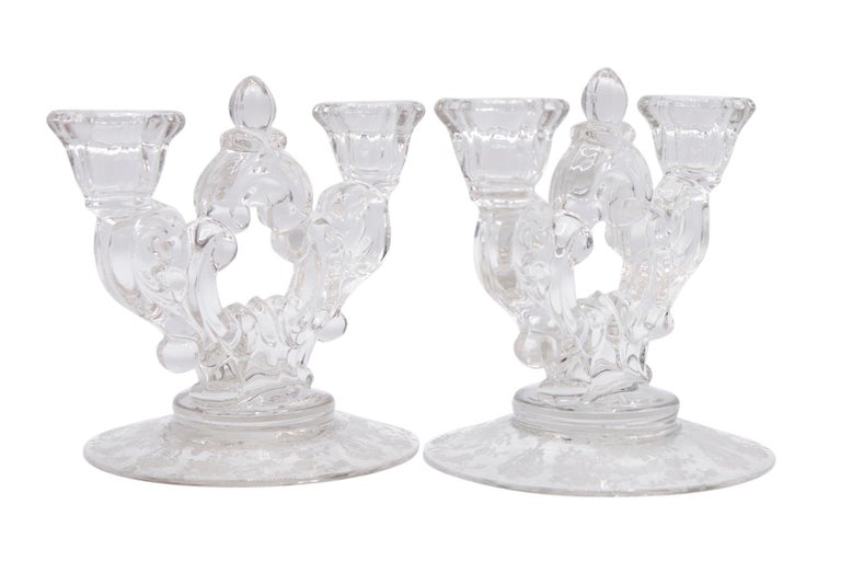 A pair of 1940’s etched glass candelabra made by Cambridge Glass. Two reeded capitals are supported with scrolled stems that meet with an acorn finial at the center. The base is etched with their intricate Wildflower pattern. Dimensions per