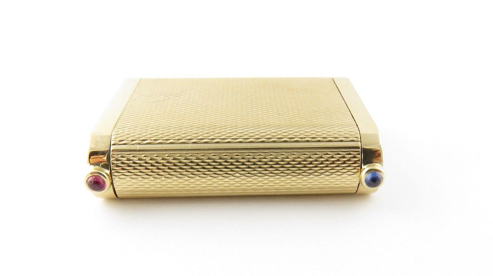 Vintage Cartier 14-karat yellow gold double pill box. This authentic Cartier pill box is approximate 35 mm x 28 mm x 9 mm. Each end opens for 2 separate compartments. One end has a bezel set cabochon blue sapphire - the other a cabochon red ruby.