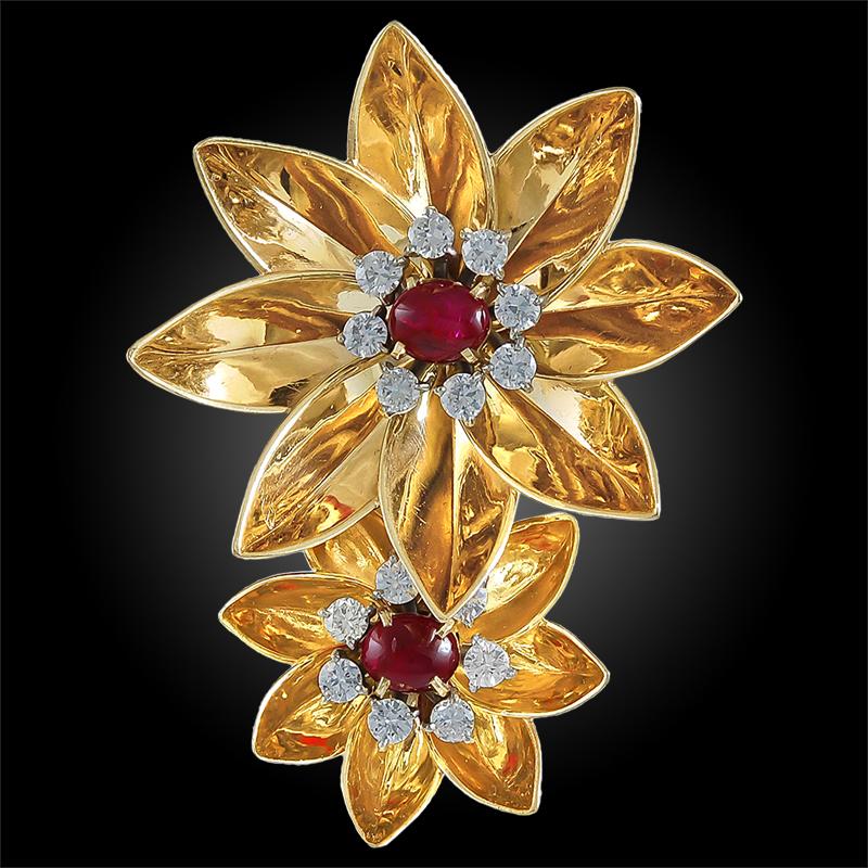 An exquisite piece by Cartier dating back to the 1940s, comprising a brooch designed as two flower heads made of 14k rose gold, each centering a cabochon ruby surrounded by a frame of brilliant diamonds.
Signed Cartier