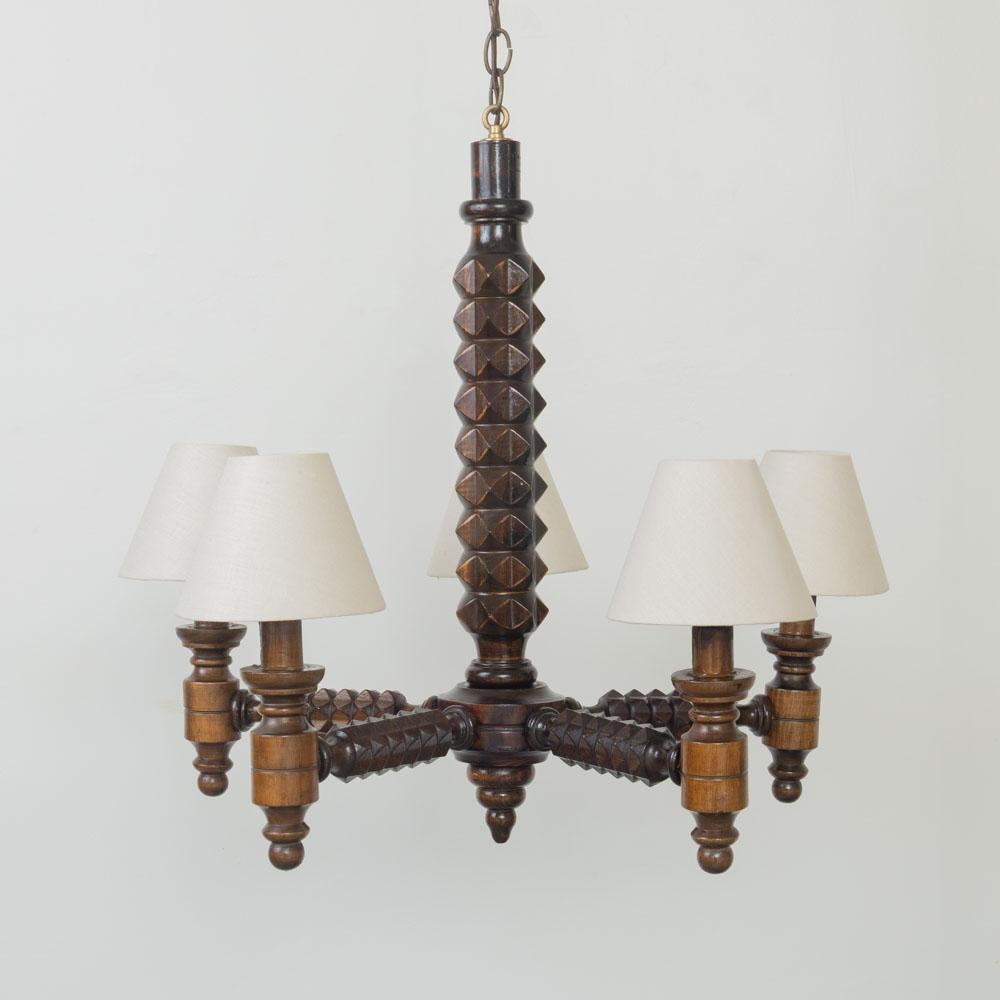 Singular lámpara de araña de madera tallada de Charles Dudouyt, Francia, años 40. Lámpara de araña con cinco brazos geométricos de madera tallada. Recién recableada con enchufes de latón de base candelabro y cuelga de una cadena de latón antiguo con
