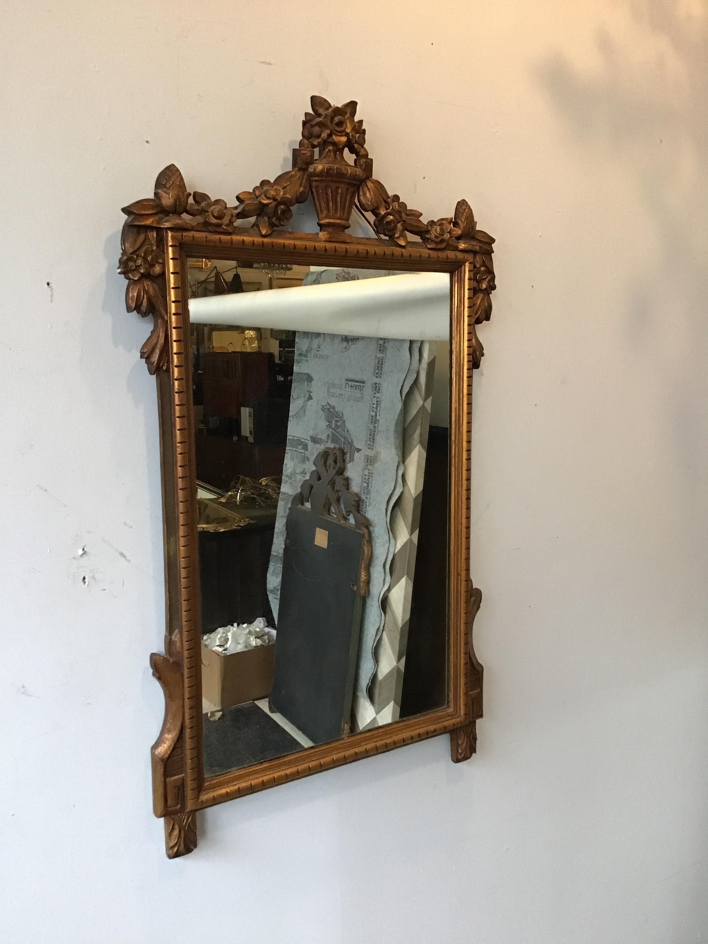 1940s carved wood French mirror with urn on top.