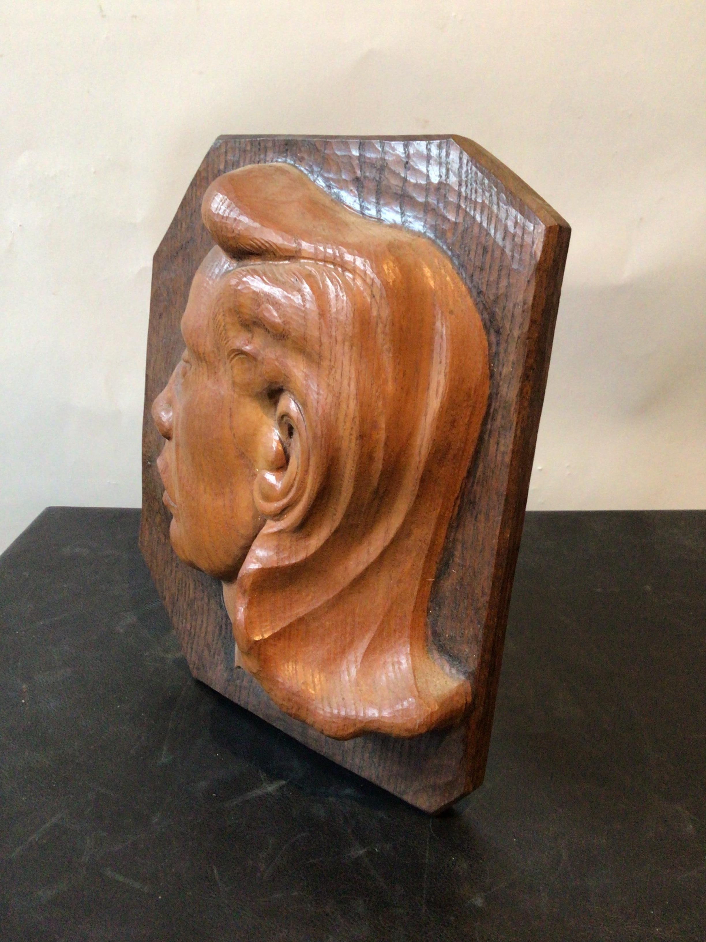 Plaque en bois sculpté des années 1940 représentant un profil de femme.