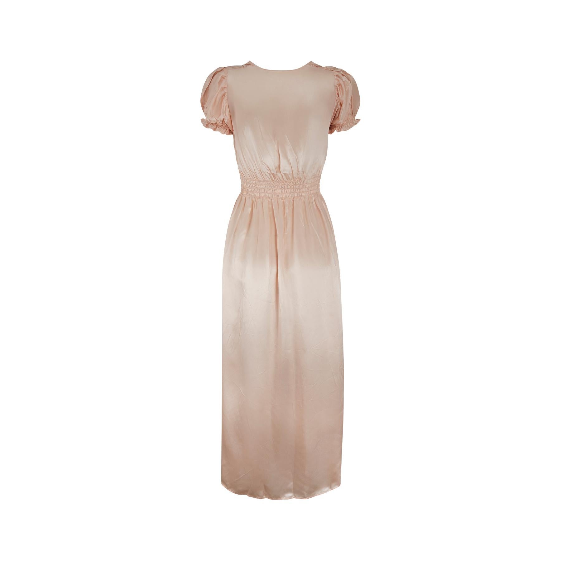 This is a really superb example of early 1940s trousseau nightwear in a wonderful soft peach satin fabric. This dress has elasticated sleeves and a smocked elasticated waistline. The ruffle neckline and dainty puff sleeves make this such a charming