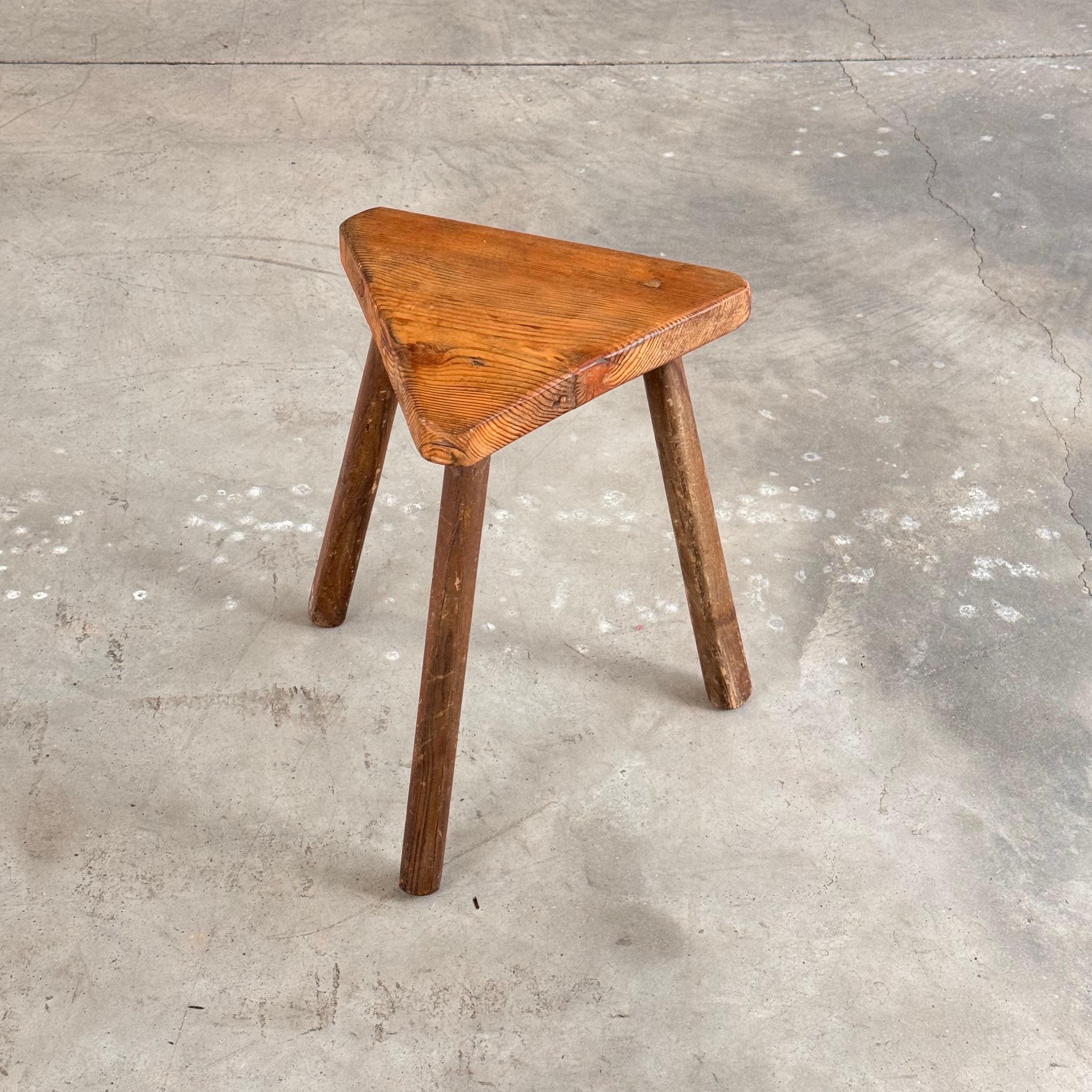 Un accattivante sgabello rustico degli anni '40, realizzato in Italia con una caratteristica forma scultorea triangolare. Questo pezzo emana carattere e presenta una splendida patina che si è sviluppata naturalmente nel tempo, aggiungendo profondità