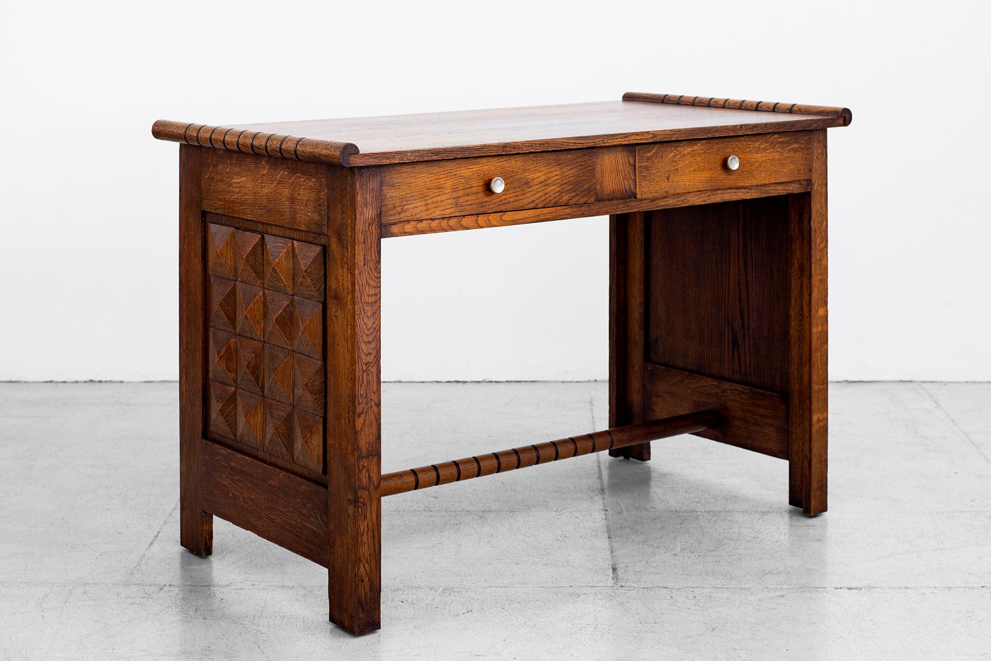 Gorgeous desk by Charles Dudouyt, circa 1940s.
Carved French oak geometric side panels and ornate detailed design throughout.
Two drawers with original hardware.
Great size and scale!

 