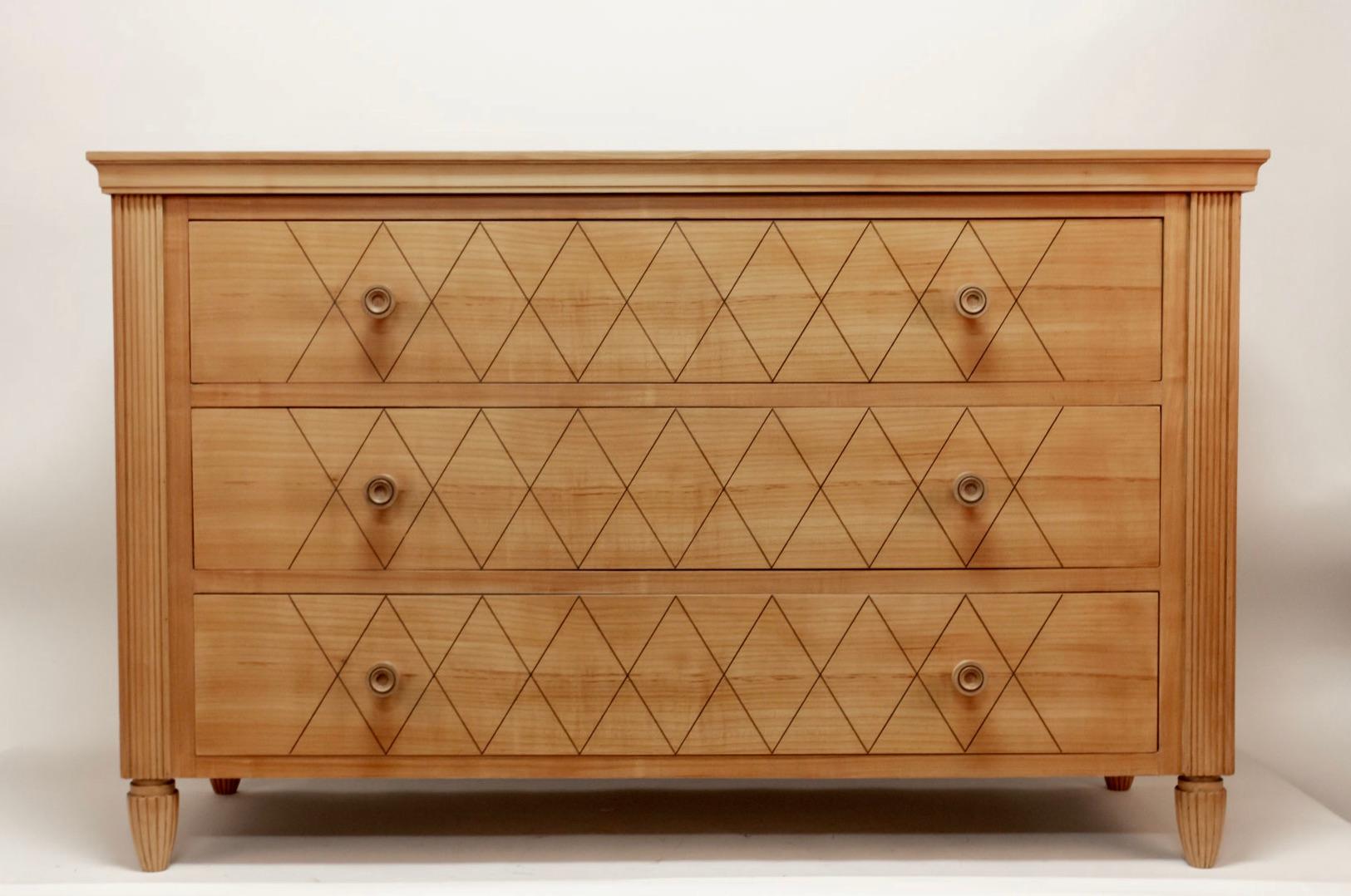 Elegant French commode or chest of drawers made of cherrywood and oak, circa 1940.
High woodworking quality, dovetail joints and turned wood handles.
The three drawers are adorned with a diamond pattern. The four corners are fluted as well as the