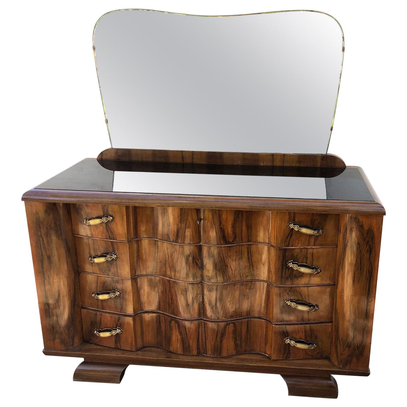 1940's chest of drawers in rosewood and walnut, honeycomb, natural color, original Italian design, black glass top, shaped mirror part.
From the same series in the shop there are ads for a chest of drawers and a pair of bedside tables.
They will be