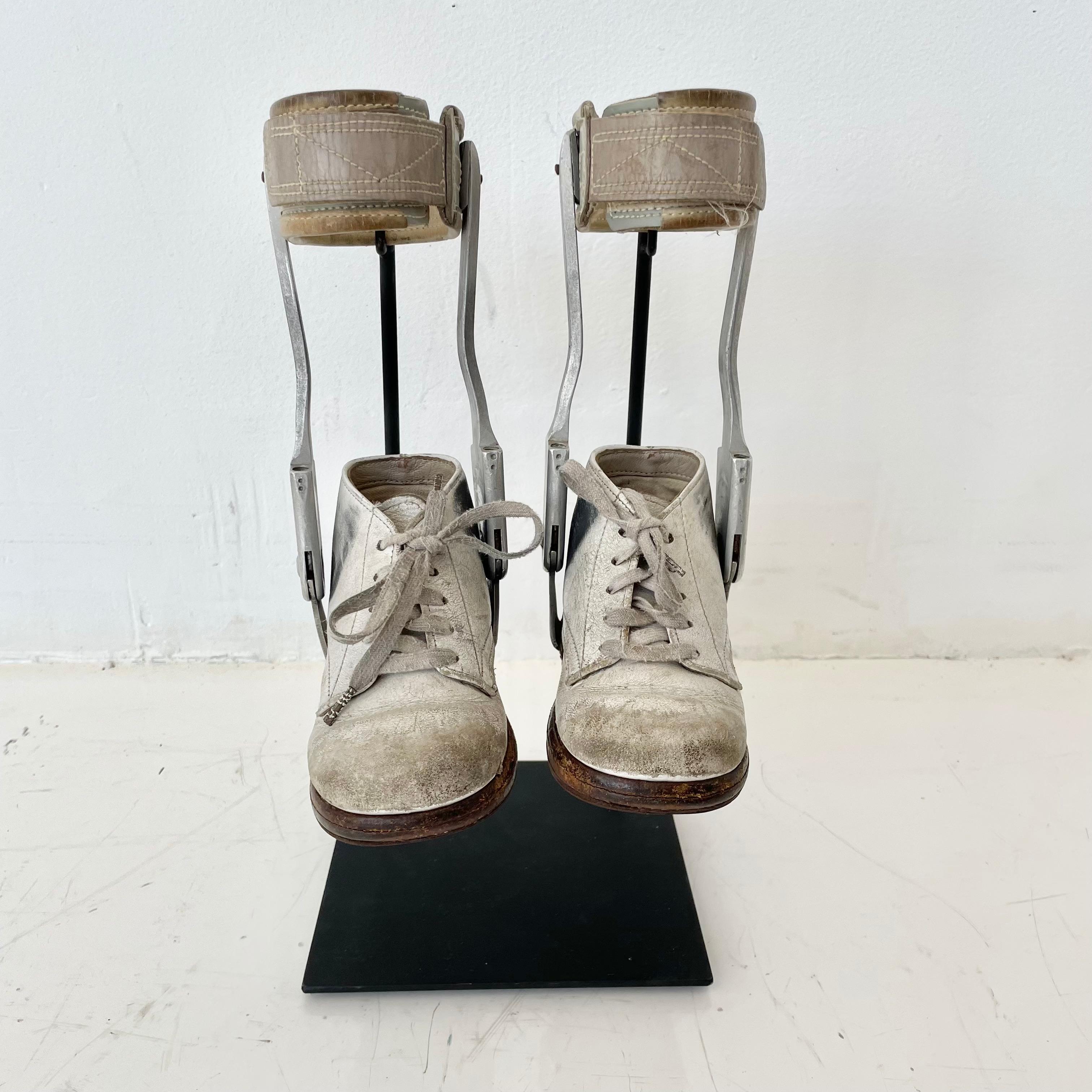 Made in the 1940s, these vintage children's leg braces are an interesting piece of medical history. Fitted for Polio patients. The leg brace is made from chrome plated steel braces and orthopedic leather. Custom iron stands that display them nicely.