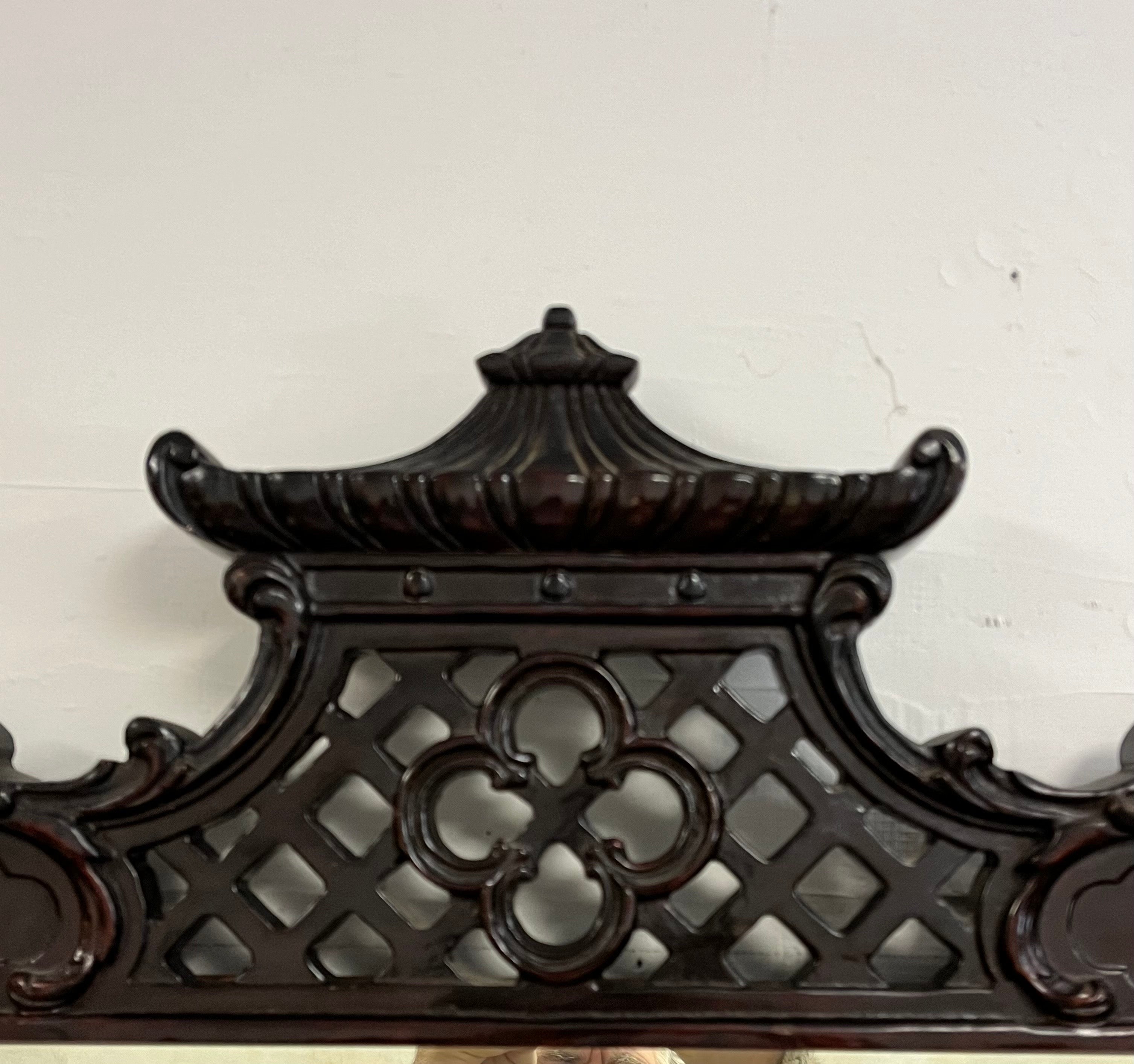 Maravilloso espejo Pagoda. Wing Furniture Company de Nueva York, década de 1940. Gran detalle de Chinoiserie con pagoda de filigrana profundamente tallada acompañada de acentos de doble columna a lo largo del borde. Caoba profunda y rica en pátina.