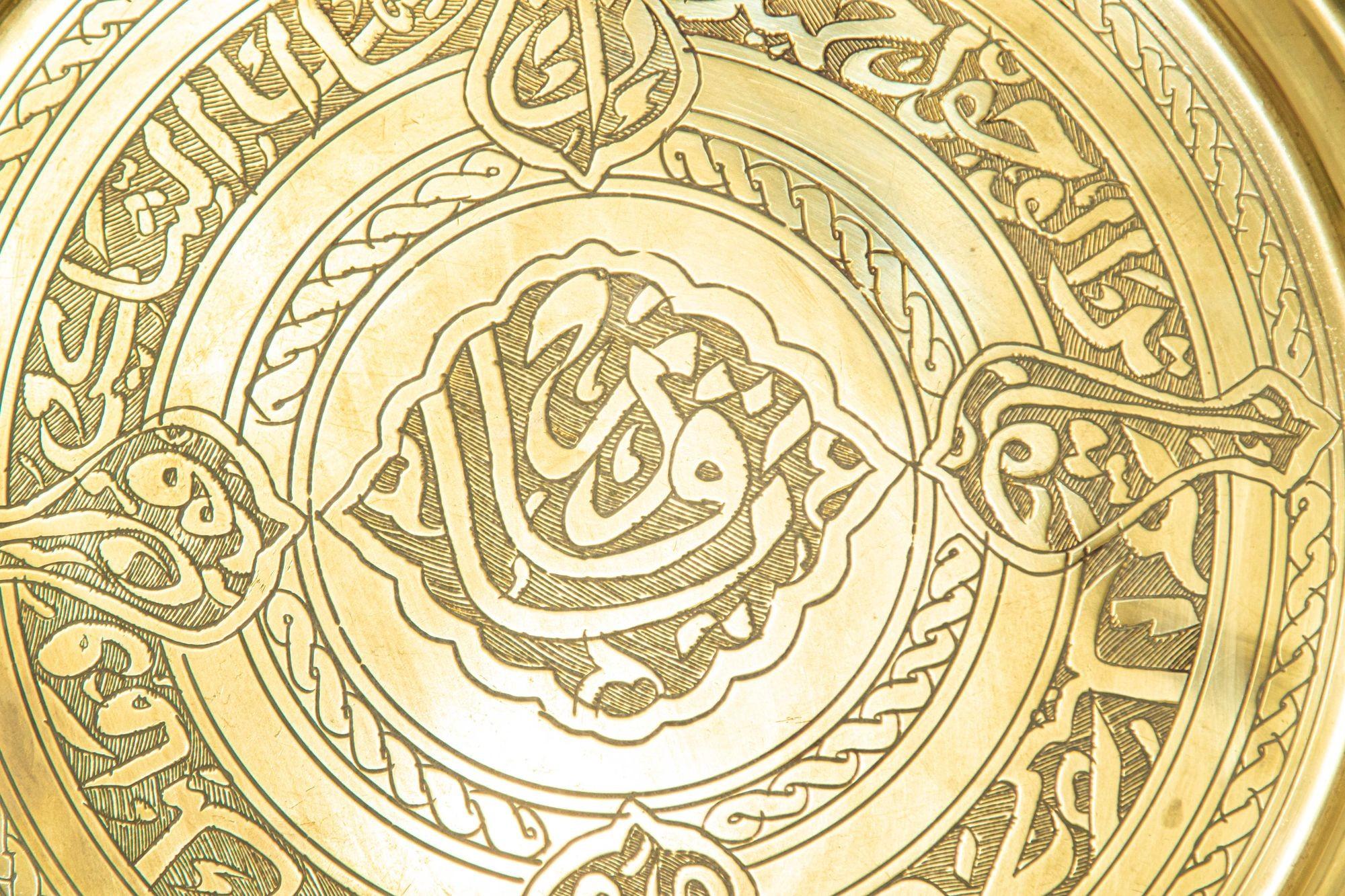 1940s Collectible Islamic Brass Round Tray , handcrafted, hammered and chased with intricate designs and Arabic writing.
Decorative circular antique polished brass tray with etched signature of the artist maker on top pf the tray.
Dimensions: 12.5