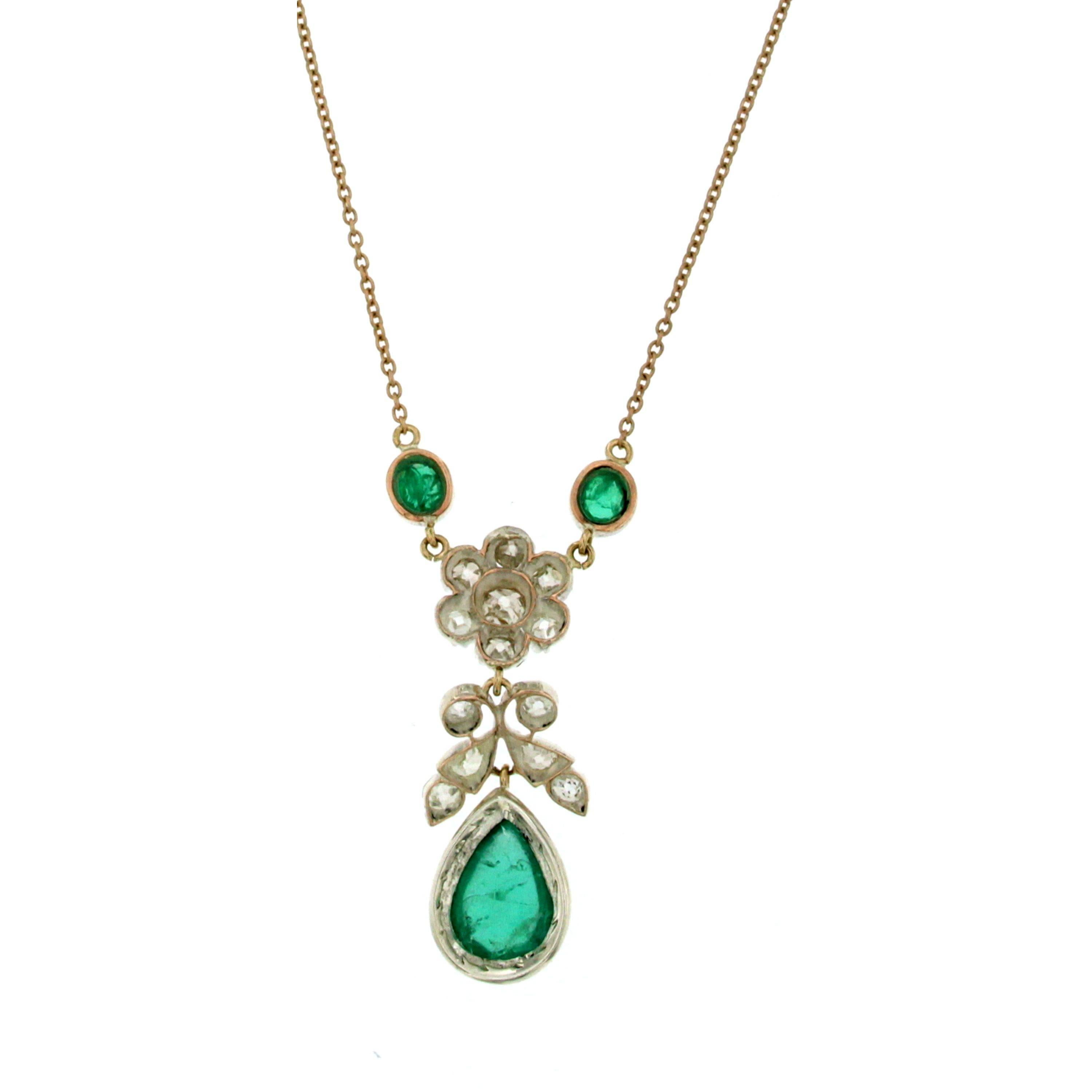 A beautiful 18 karat yellow and white gold necklace featuring at the bottom a drop shape Natural Vivid Cabochon Emerald, Colombian origin, weighing 2,60 carat, set in an Old Mine cut Diamonds flower and leaves design suspended by two oval Colombian
