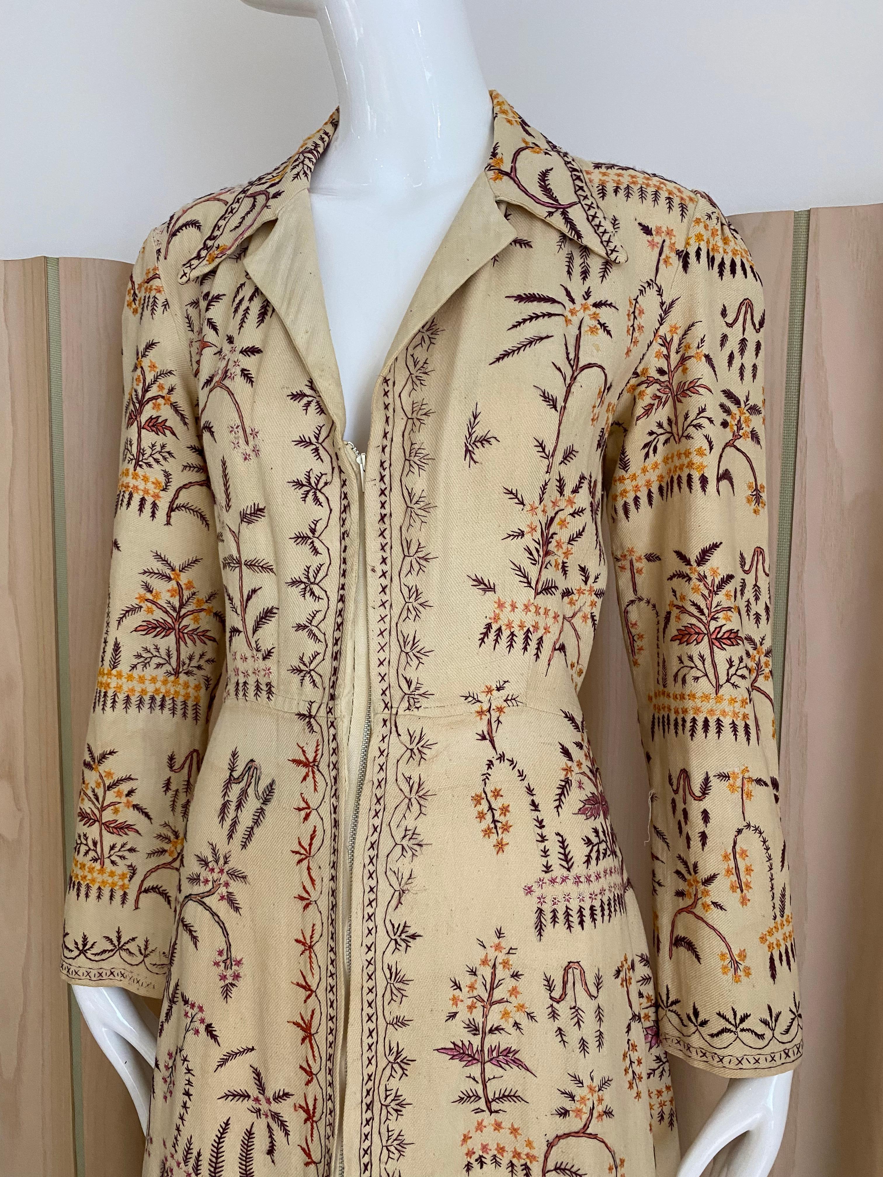 1940s Cream Cotton coat dress embroidered with multi color yellow, brown, red and pinks ferns .
- Long sleeves
- Front zipper
Size Medium
Measurement: B 38” / W 30”  / Hip  40” / Shoulder: 19” / Sleeve length / Dress length: front hem 54/ back hem
