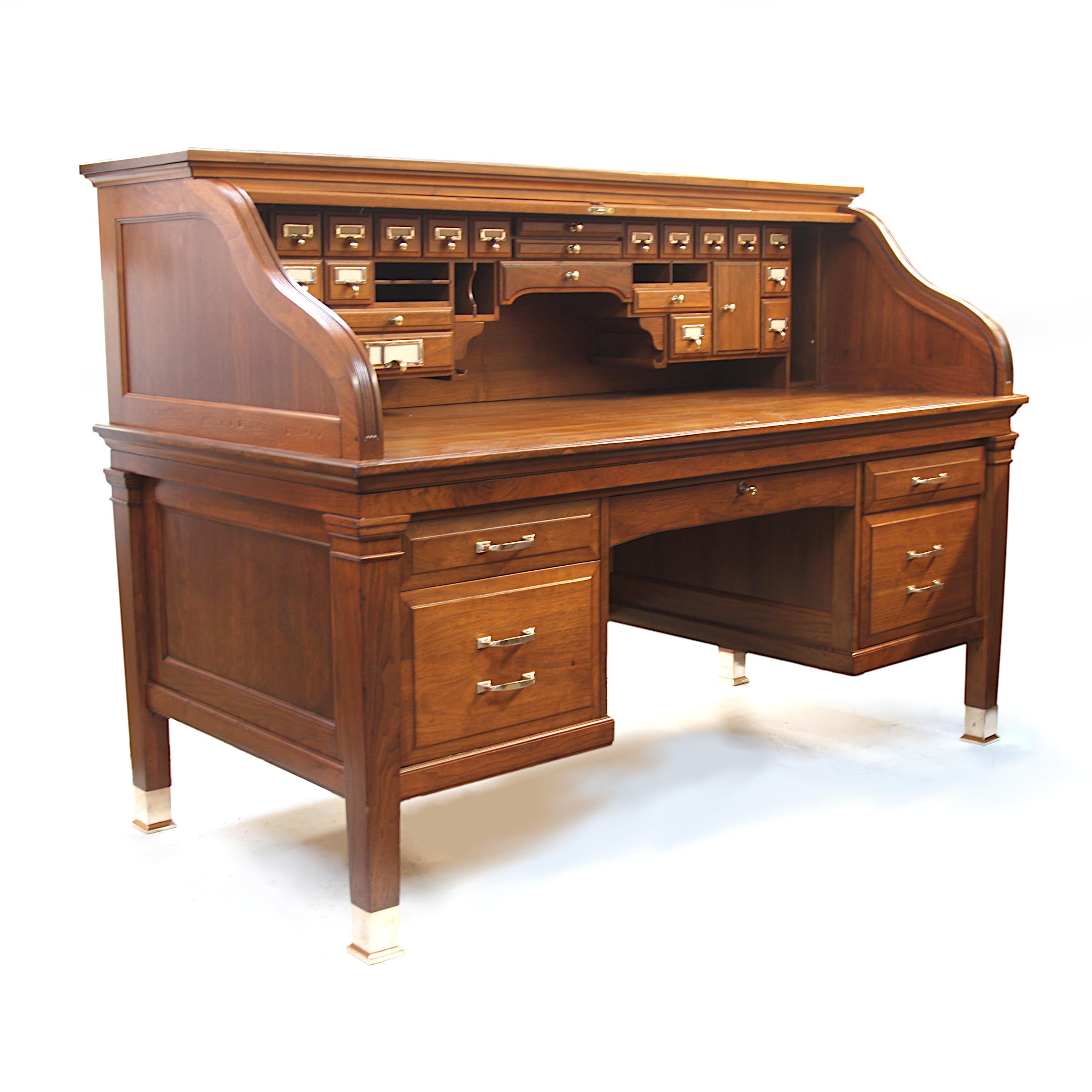 Wonderful 1940's vintage Roll top desk. Desk features S-curve tambour roll, solid brass hardware/feet, raised panel drawers, Empire styled details and grand scale! This is a fantastic looking desk that would make an impressive addition to any home