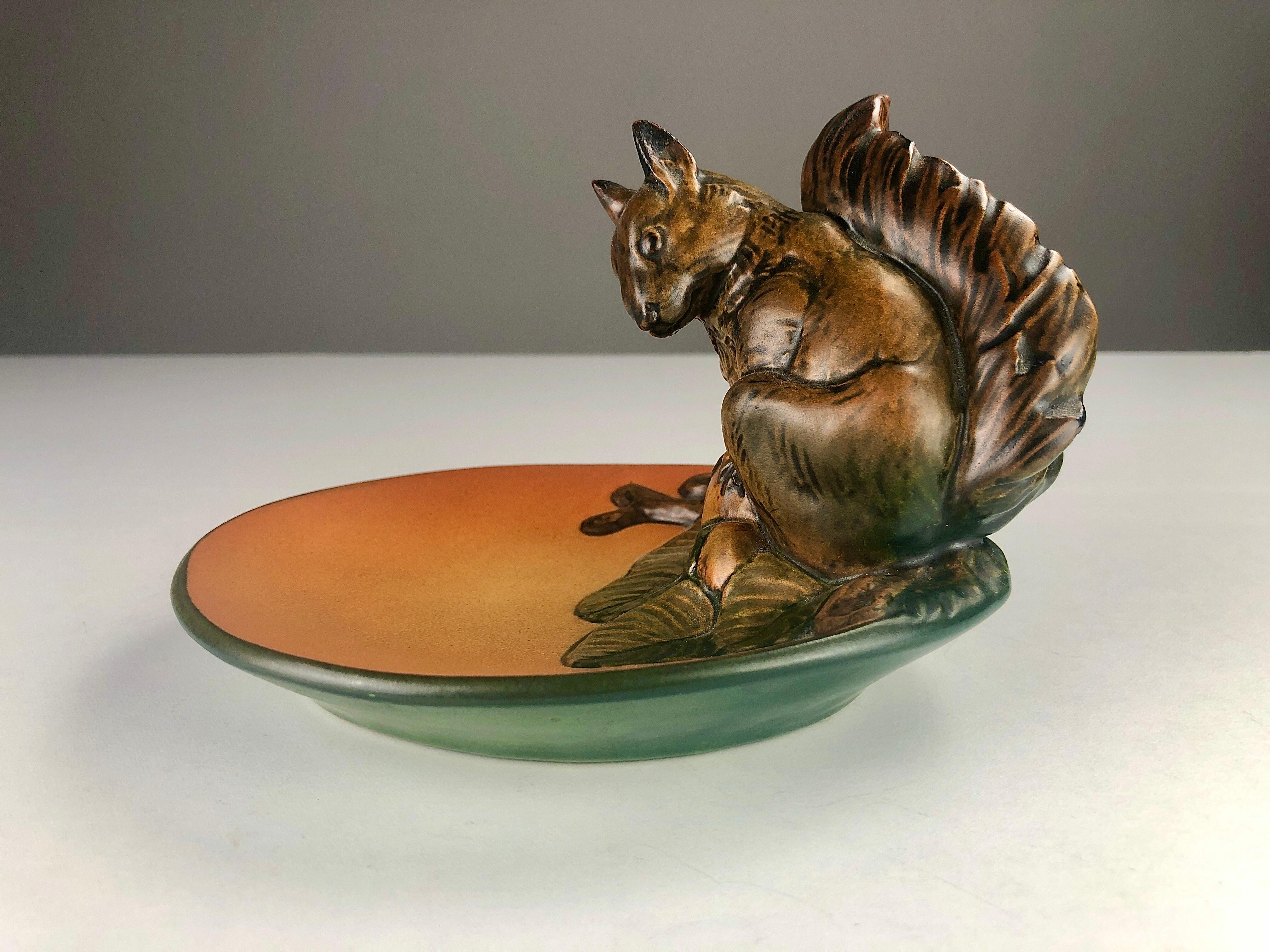 Hand-crafted Danish Art Nouveau ash tray / bowl by Axel Sørensen for Ipsens Enke

The art nuveau ash tray / bowl feature a well made lively squirrel and is in excellent condition.

Ipsens Enke (1843 - 1955) was a very succesfull company that