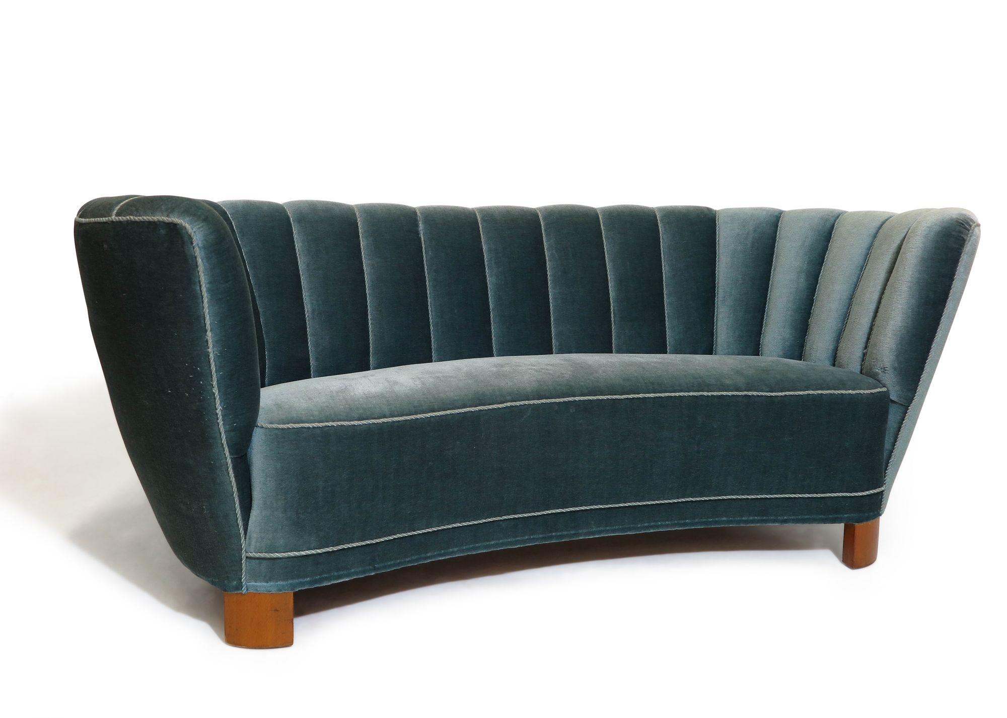 This amazing 1940s Danish channel back settee is a stunning addition to any room. Boasting a solid wood frame with eight-way hand-tied springs, horsehair and cotton padding, this masterfully crafted curved-back settee is covered in the original blue