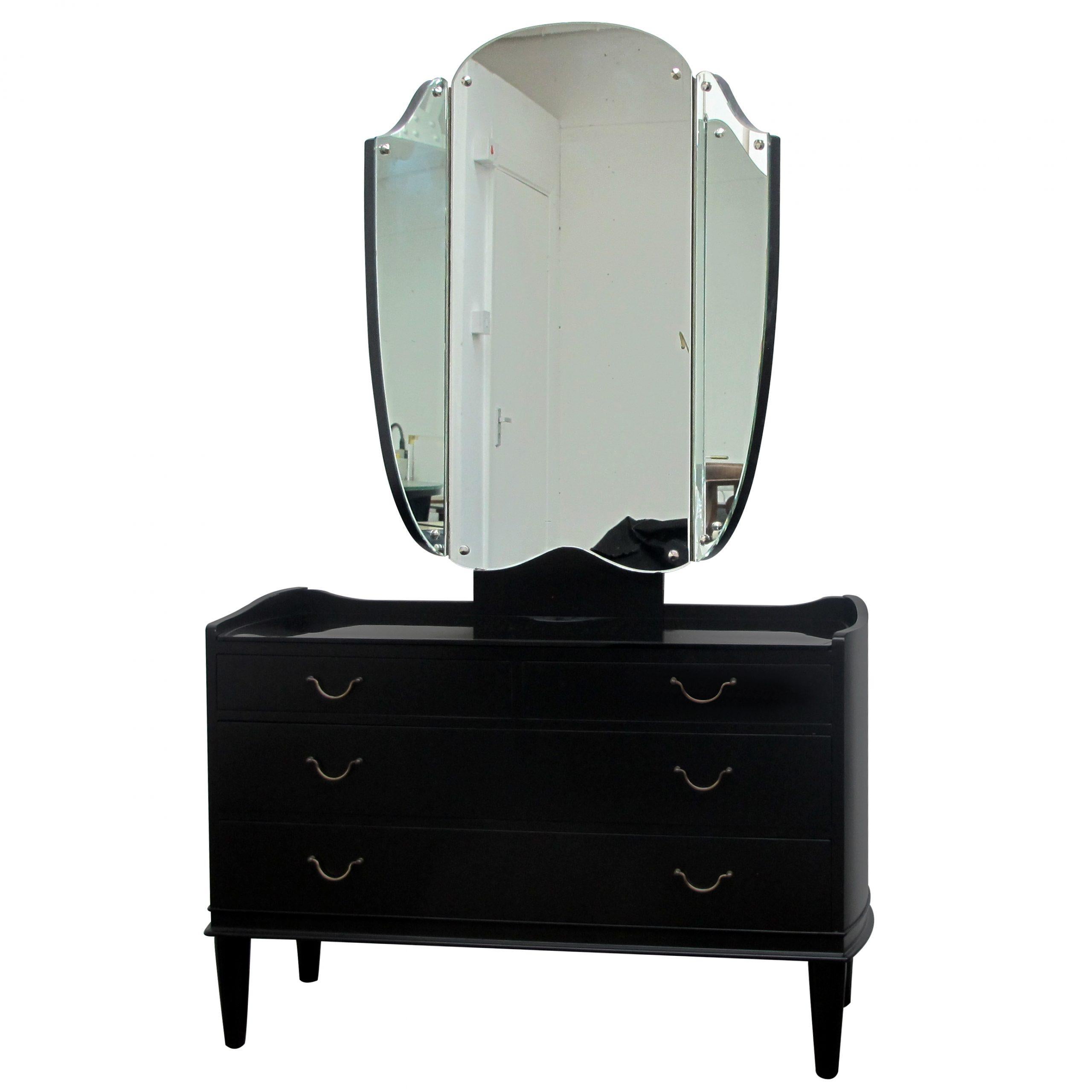 1940s dressing table with a black etched glass top, its original triptych mirror and brass handles. The vanity dressing table offers plenty of storage with its three long drawers. This is a truly elegant minimalistic design.

Size: H161 cm x W101 cm