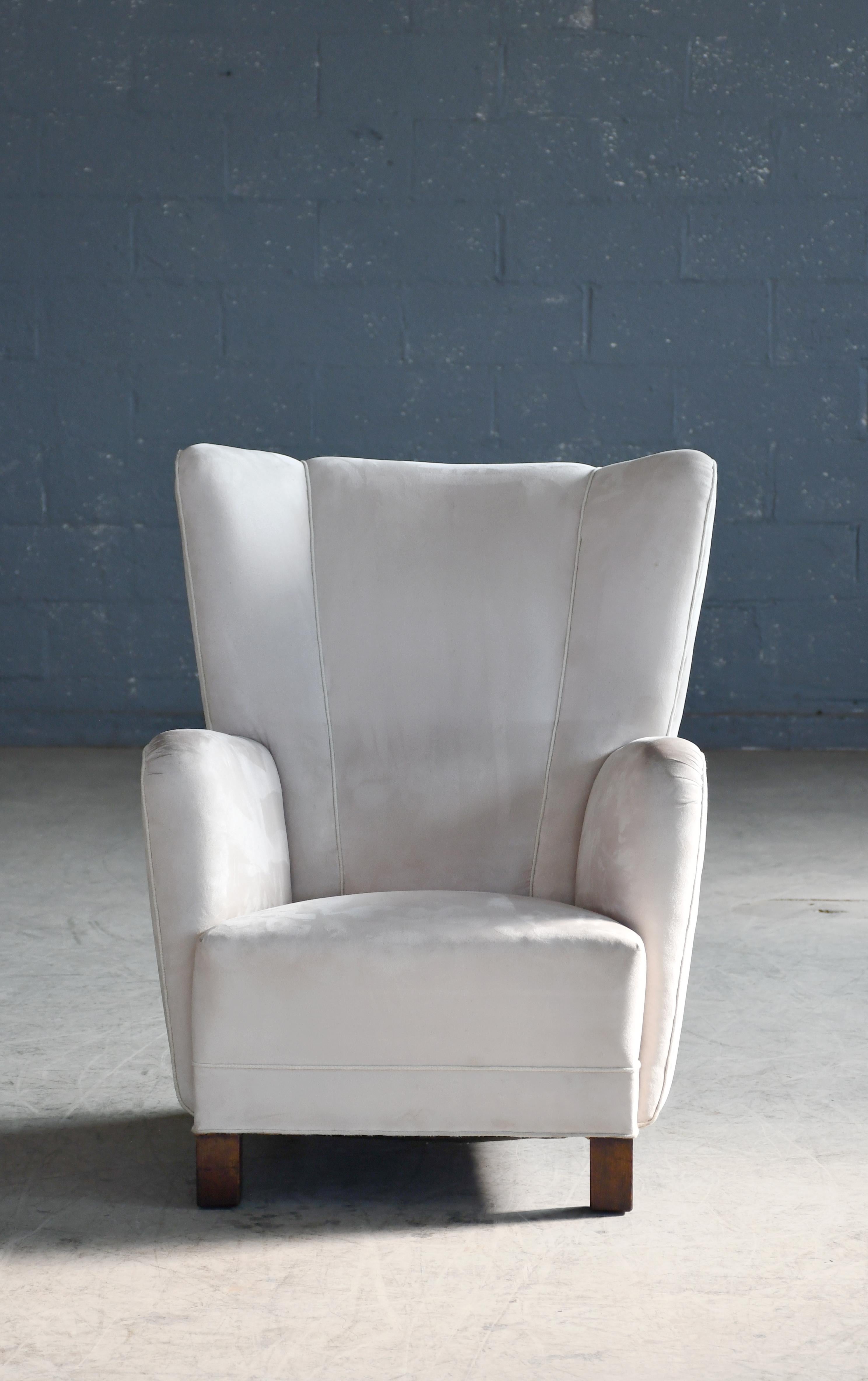 Unique highback lounge chair with smooth backrest made in Denmark in the late 1930s or early 1940s. Similar to Fritz Hansen's famous model 1672. Solid and sturdy with coil springs in the seat and backrest. Strong statement piece to anchor any room.