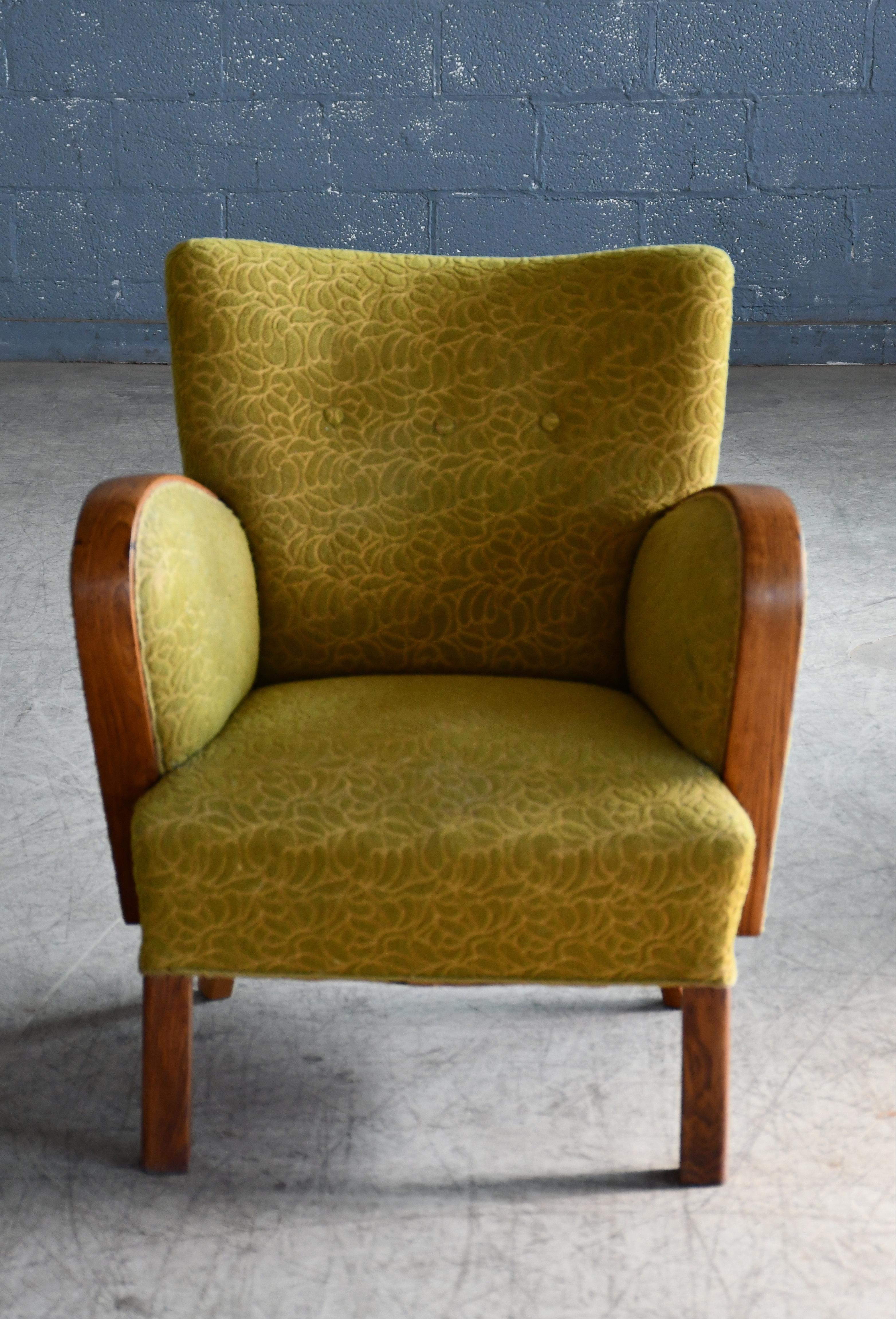 Curvy and eye-catching Danish club chair from the 1930s or 1940s. Set on oak feet typical of the art 
