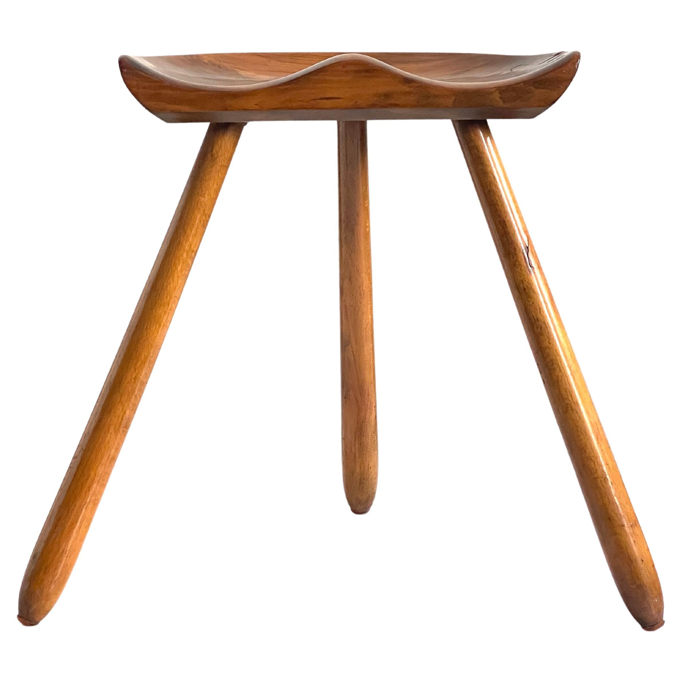 1940s Danish modern stool of beech wood with hand carved seat and tapering legs.