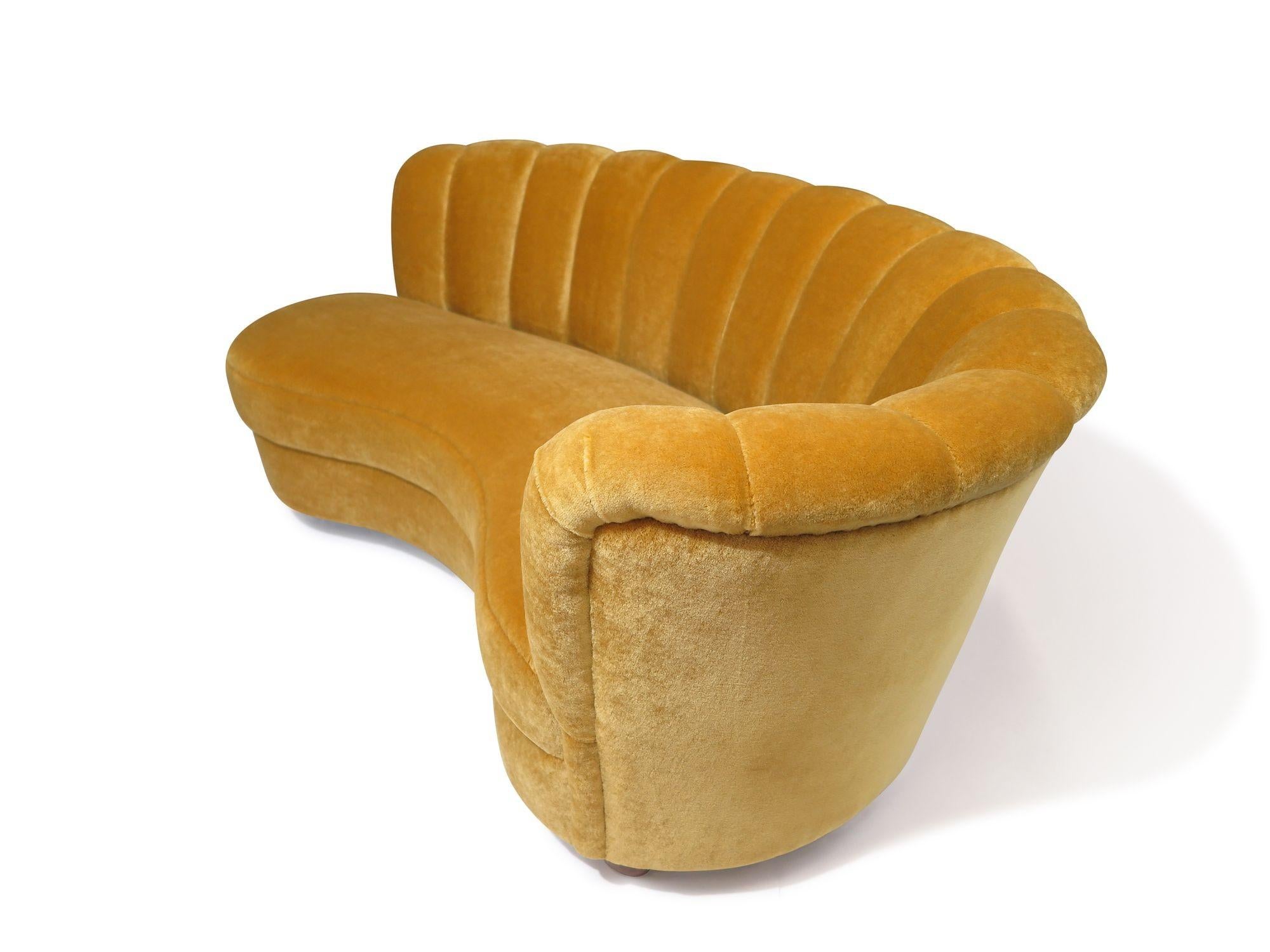Elegant 1940s Danish sofa features a gracefully curved form with vertical channel-back tufting, offering both sculptural presence and structured comfort. Built with exceptional craftsmanship, it features a solid doweled wood frame and a seat