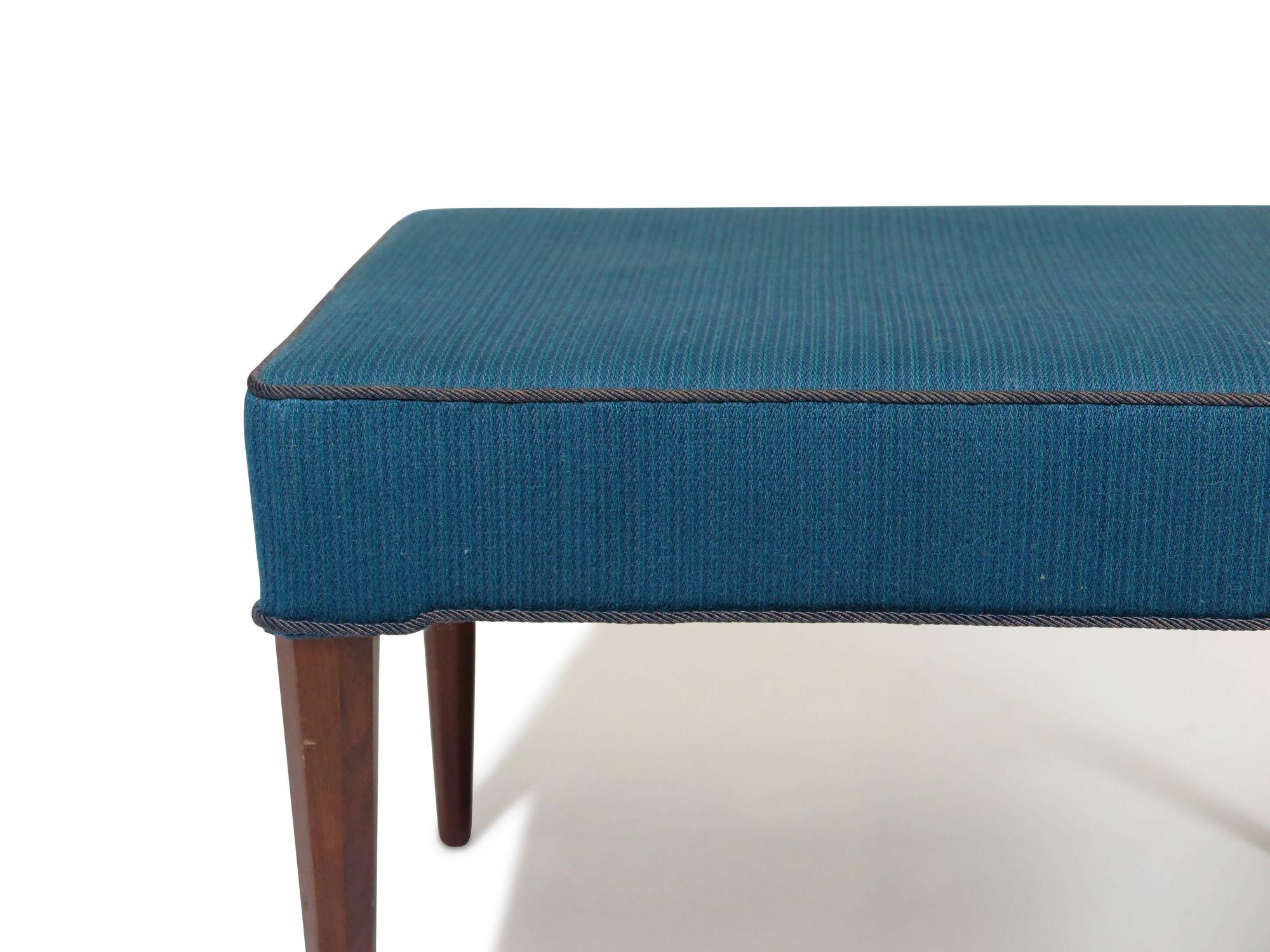 1940s Scandinavian ottoman raised on elegant mahogany legs in the manner of Frits Henningsen. The ottoman is upholstered in the original blue wool fabric and can be used in its current condition or fully upholstered in a material of your