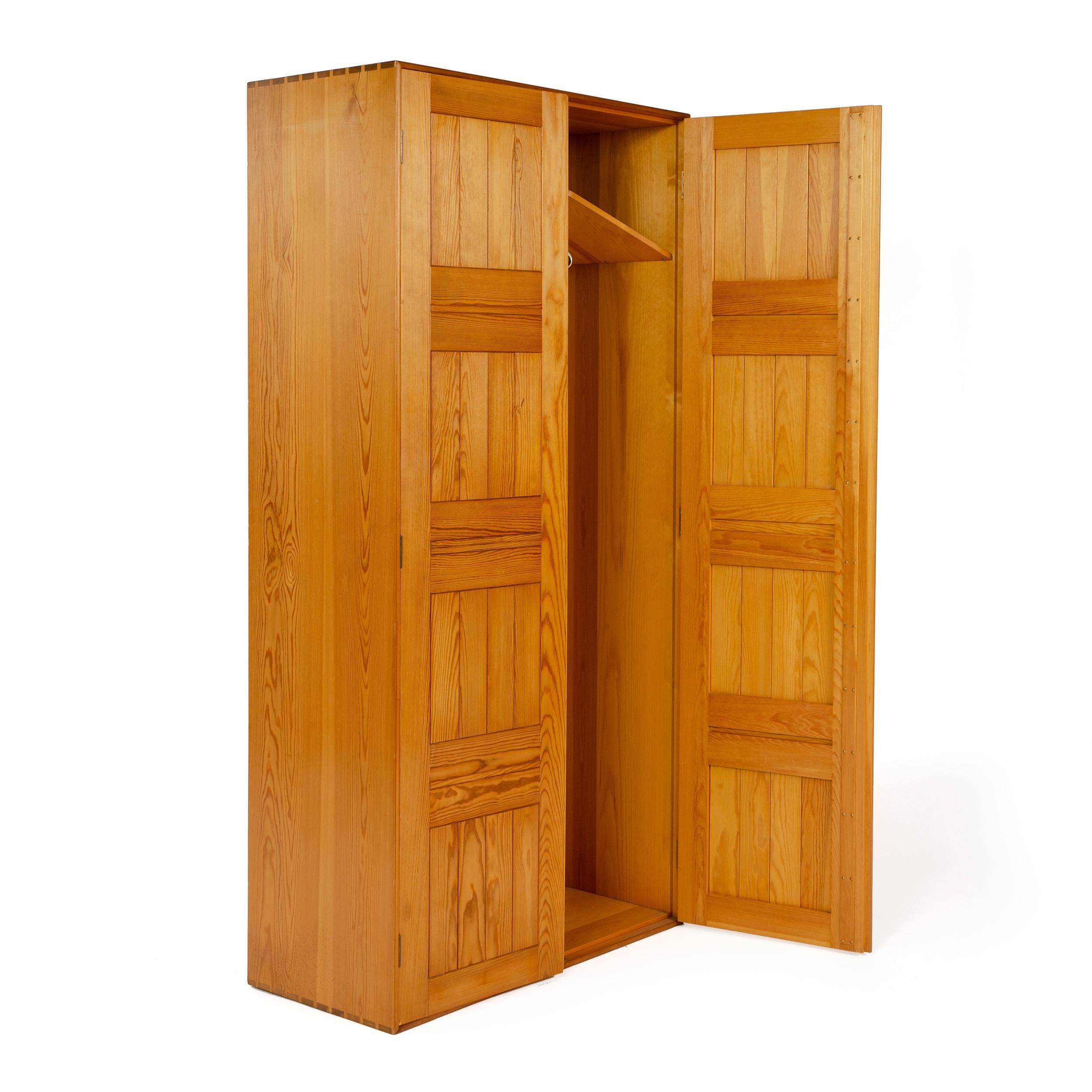 A two-door solid pine wardrobe with a dovetailed case and sliding brass hanger rod.