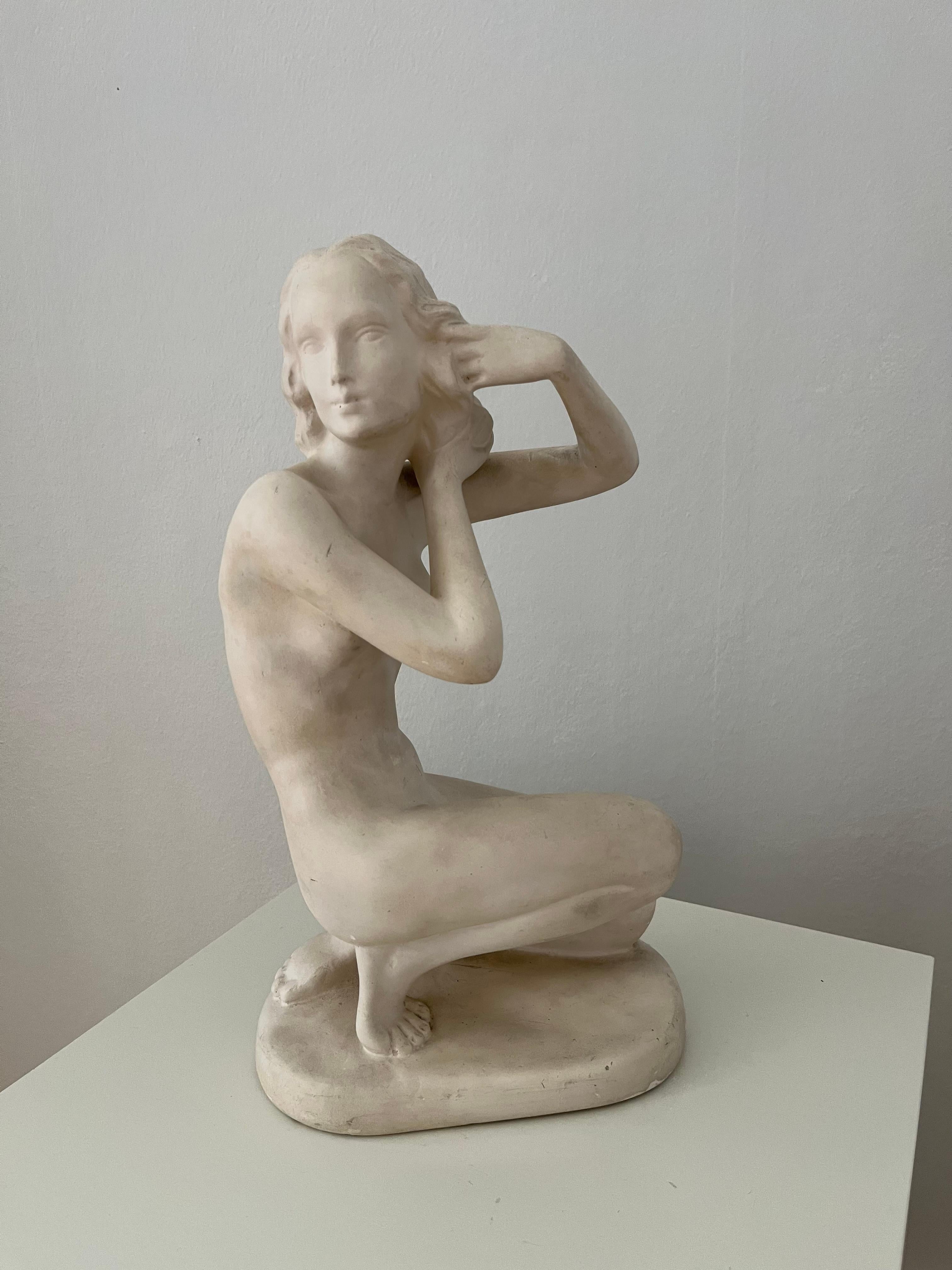Handmade figurine of a sitting woman in matte white plaster. Made in Denmark in 1940s, signed '737'. 
Very decorative piece with signs of wear and use, scratches and chips – overall patinated, the matte surface makes it more vulnerable for i.e. dust