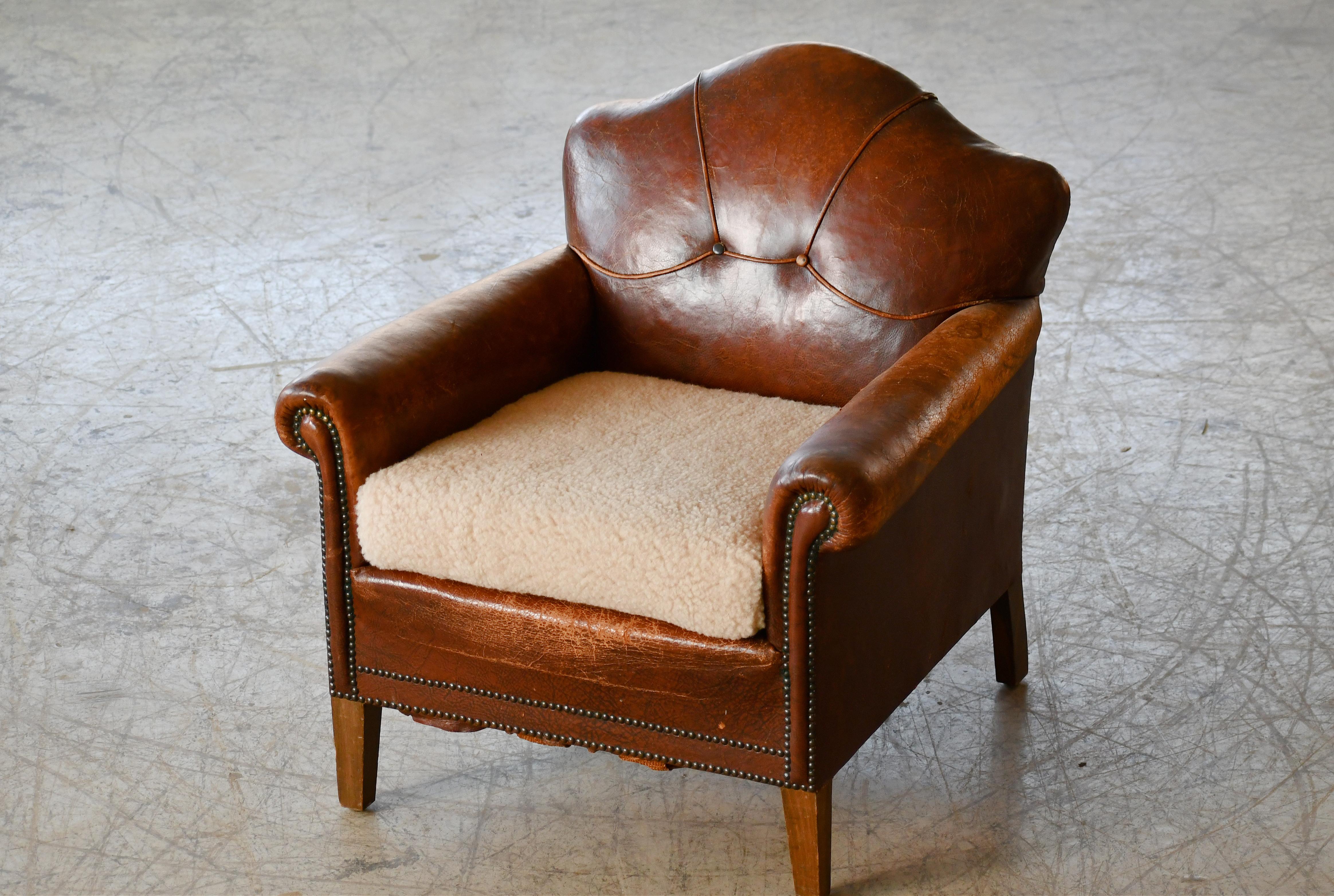 Charming cognac colored small scale Danish leather club chair made around the 1930's to 1940's. The Danes called these smaller type chairs for 
