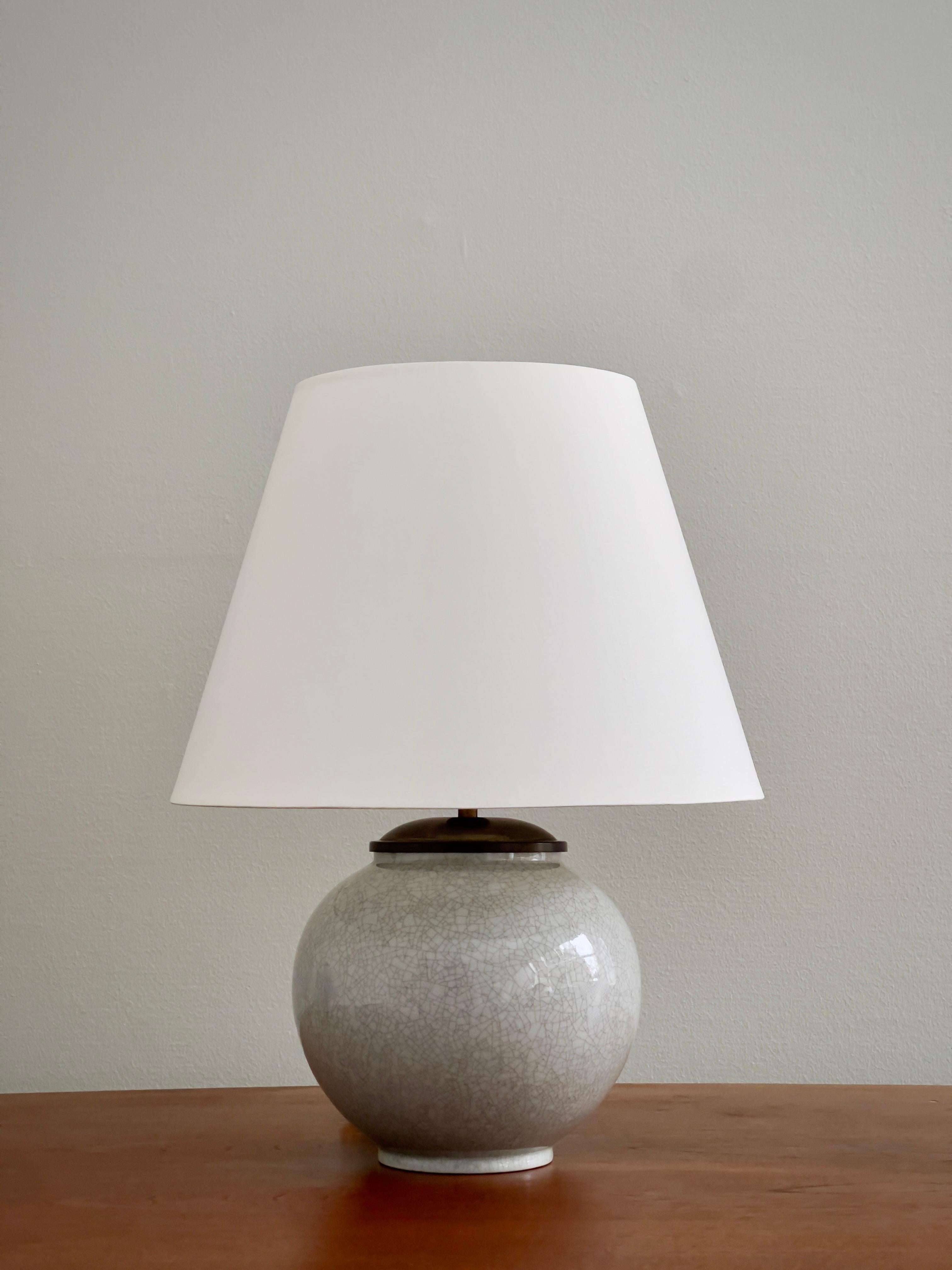 Cette rare lampe de table en céramique danoise des années 1940 de Lyngby Porcellæn illustre l'approche raffinée de la marque en matière de formes, de matériaux et de techniques d'émaillage. Son corps sphérique en céramique est élégamment