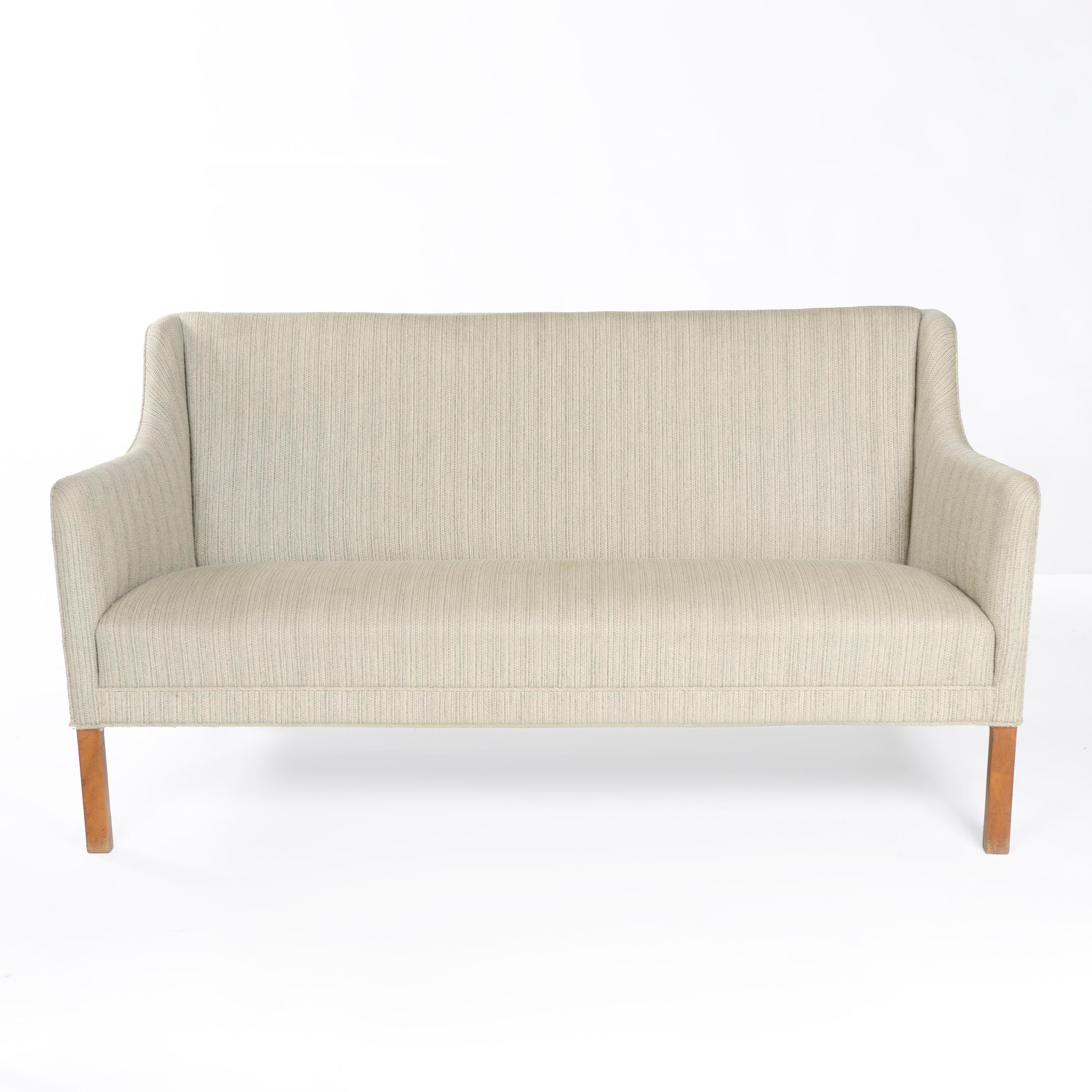 A settee with the original pale gray striated wool upholstery on chamfered beech legs.
  