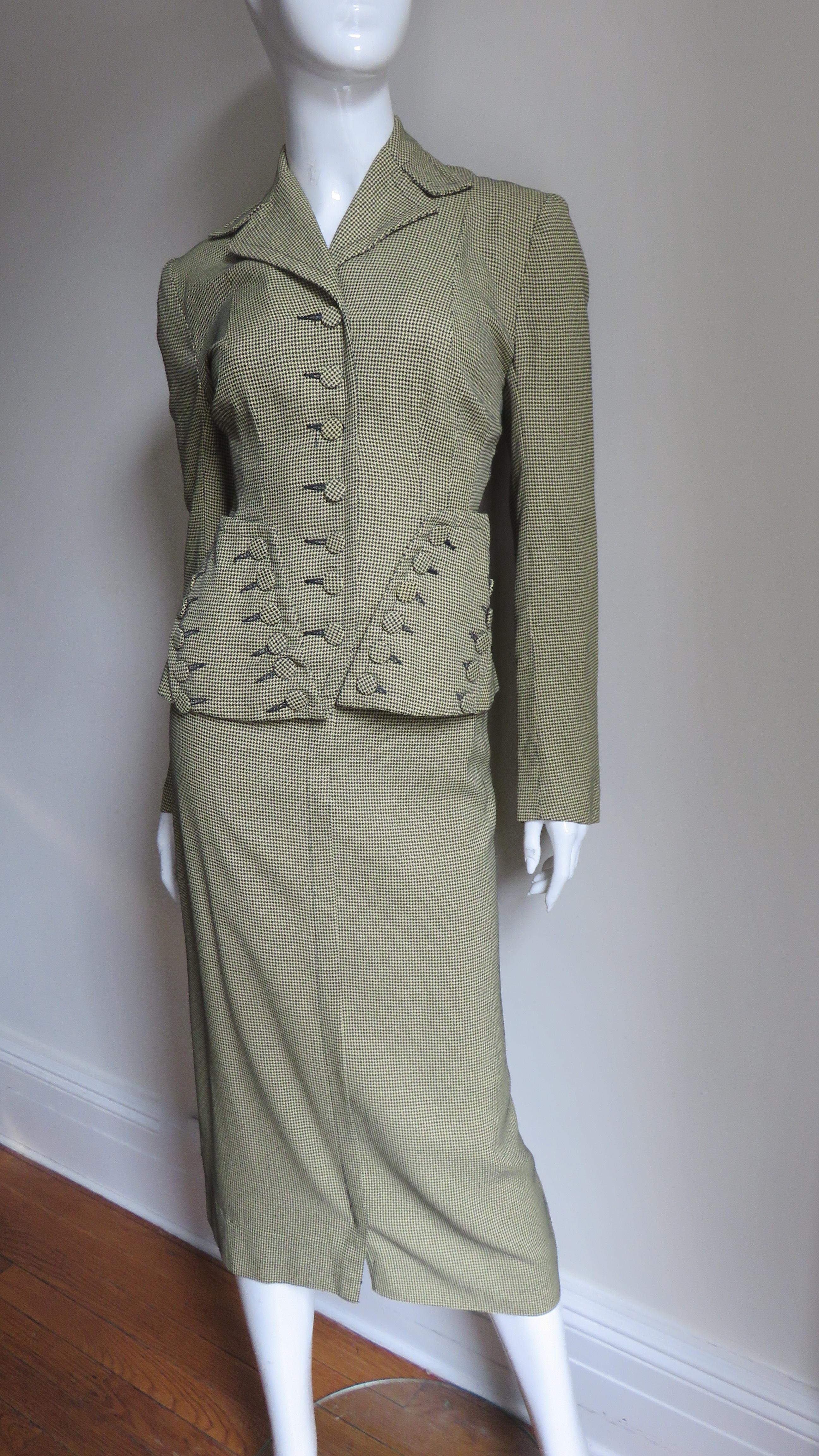 An incredible 1940s suit from Davidson's Madeleine label in a pale yellow and black fine wool small hounds tooth check pattern. The long sleeve single breasted jacket has a lapel collar, princess seams and elaborate pockets with self covered buttons